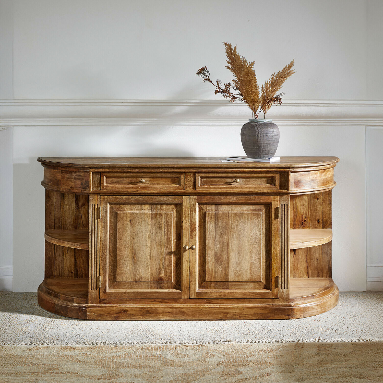 Dřevěná komoda v přírodní barvě s otevřenými policemi a zásuvkami, dekorativní váza nahoře