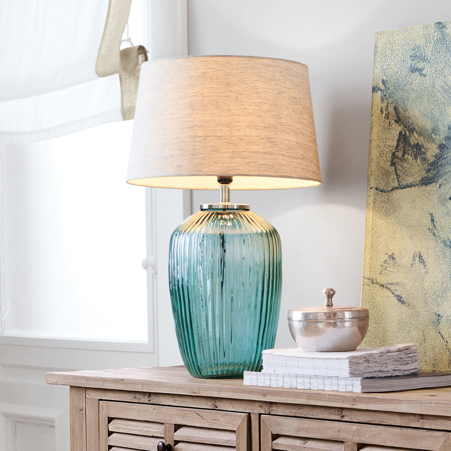 Stolní lampa Fenis Stolní lampa ze zeleného skla s béžovým stínidlem na dřevěné komodě v obývacím pokoji