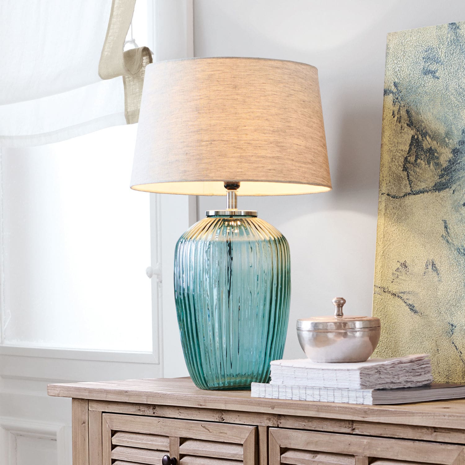 Stolní lampa Fenis Stolní lampa ze zeleného skla s béžovým stínidlem na dřevěné komodě v obývacím pokoji