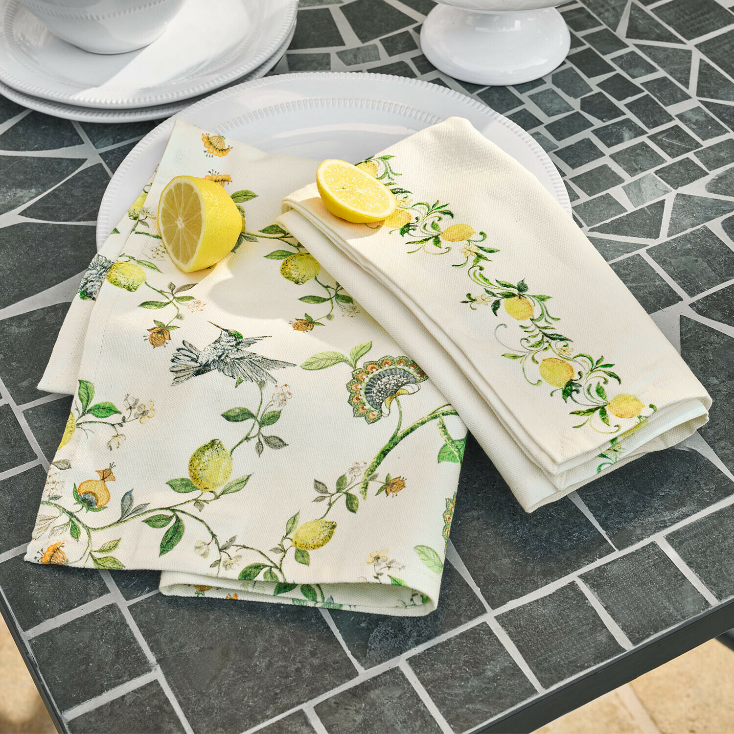 Lněné ubrousky s motivem citronů a ptáků na šedém kamenném stole pro stolní dekoraci
