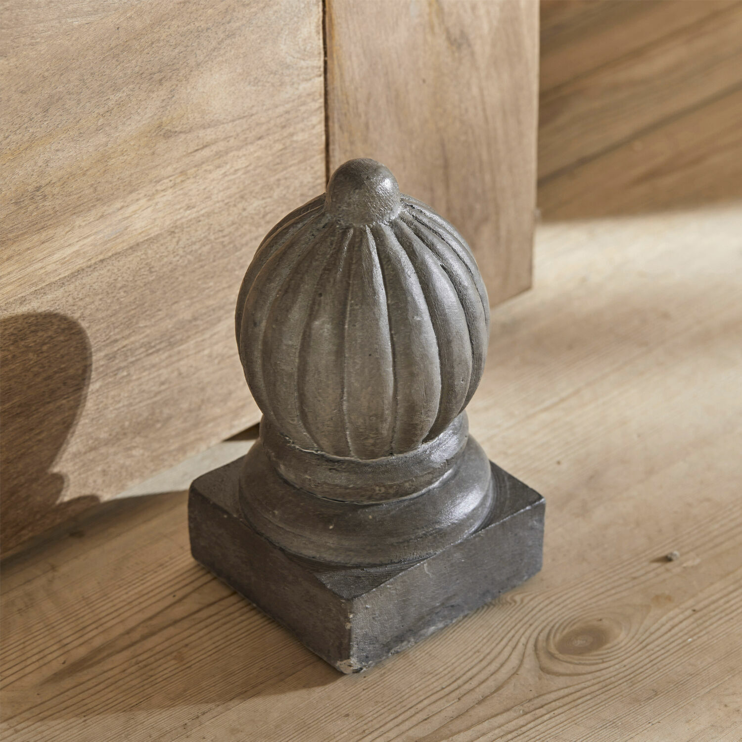 Dekorativní šedý kovový prvek ve vintage stylu na dřevěném povrchu