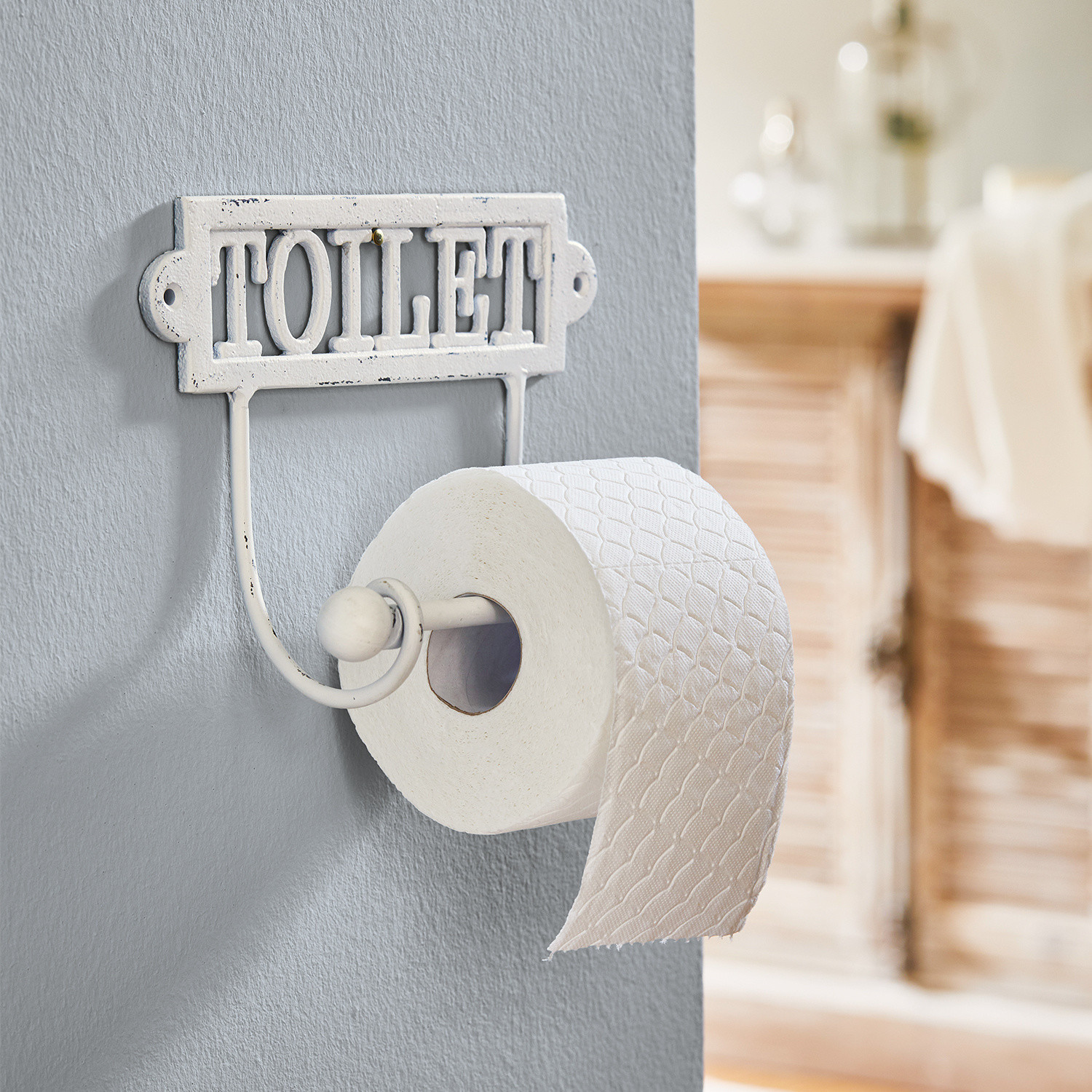 Držák na toaletní papír Miramas Bílý kovový držák toaletního papíru s nápisem TOILET do koupelny ve vintage stylu