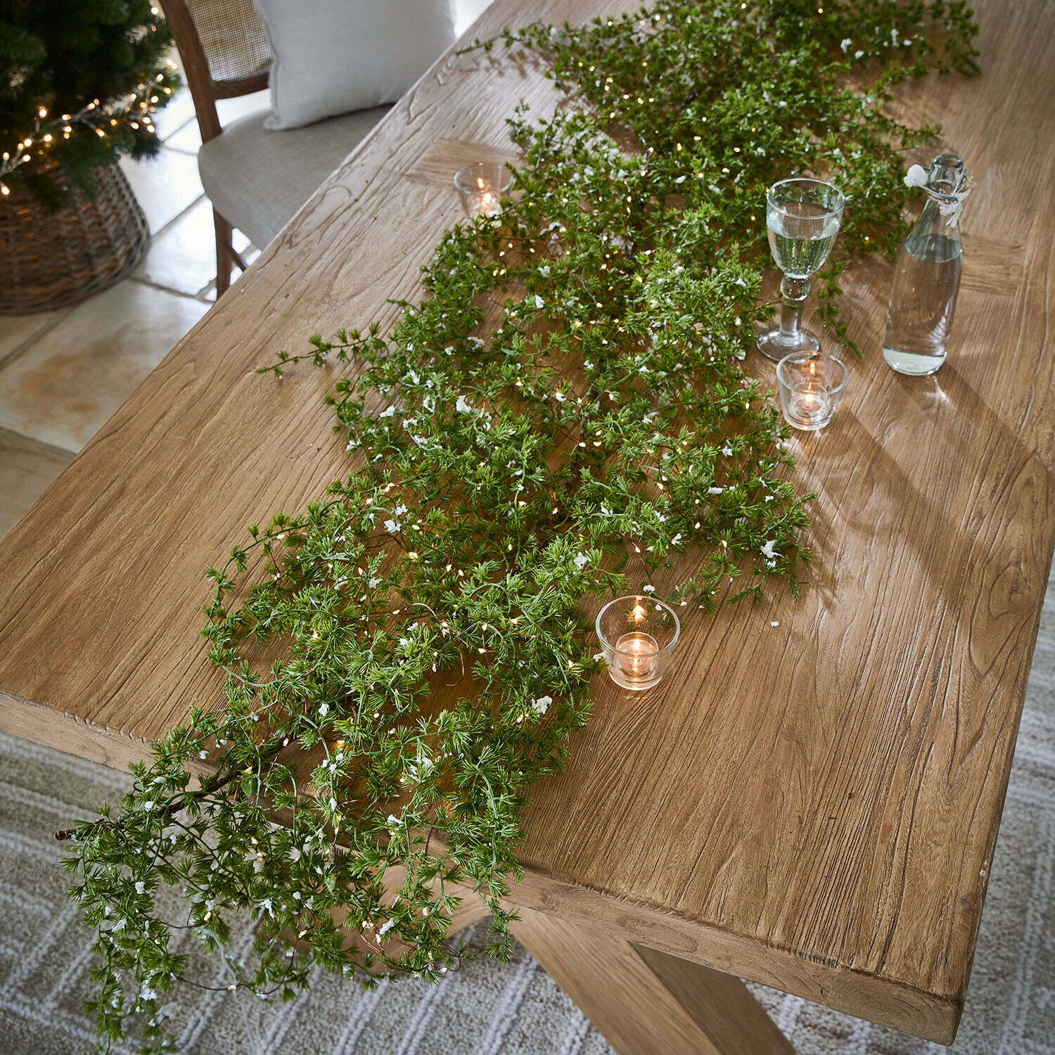 LED girlanda Kalitha Dřevěný stůl s zelenými větvičkami a svíčkami, přírodní sváteční dekorace