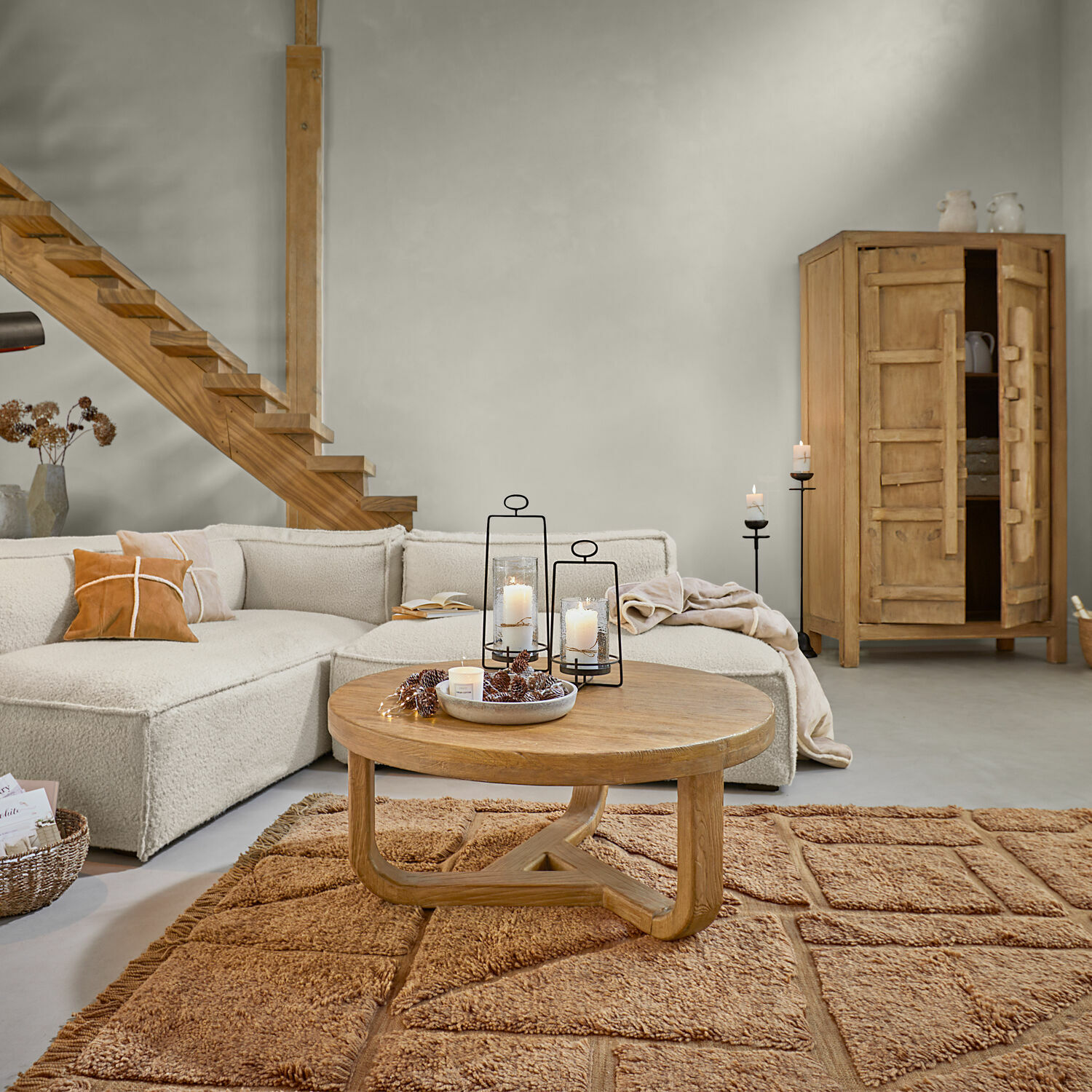 Pohodlný obývací pokoj s béžovou pohovkou, dřevěným kulatým stolem a hnědým kobercem, moderní interiér