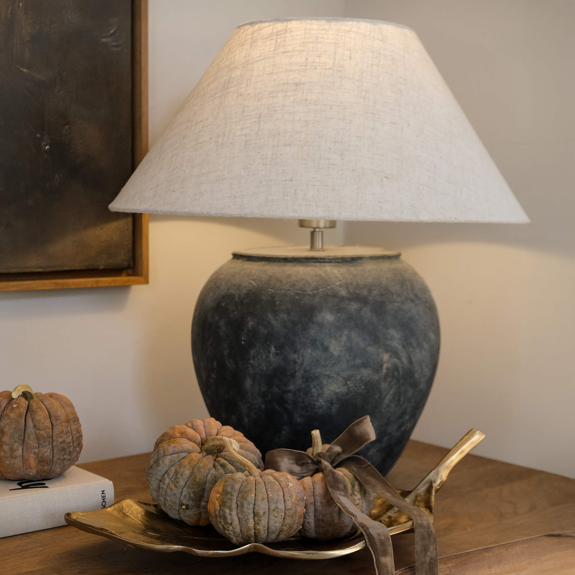 Stolní lampa z tmavě šedé keramiky s béžovým stínidlem a dekorací z malých dýní na zlatém podnosu