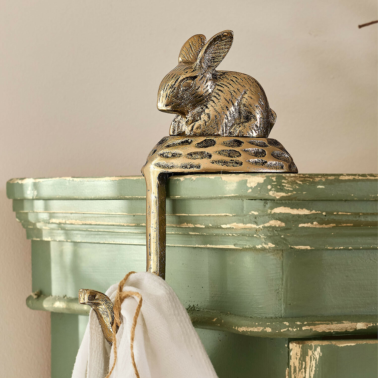 Háček Luneford Zlatý mosazný věšák na ručníky s ozdobou ve tvaru králíka na zelené postaršené polici
