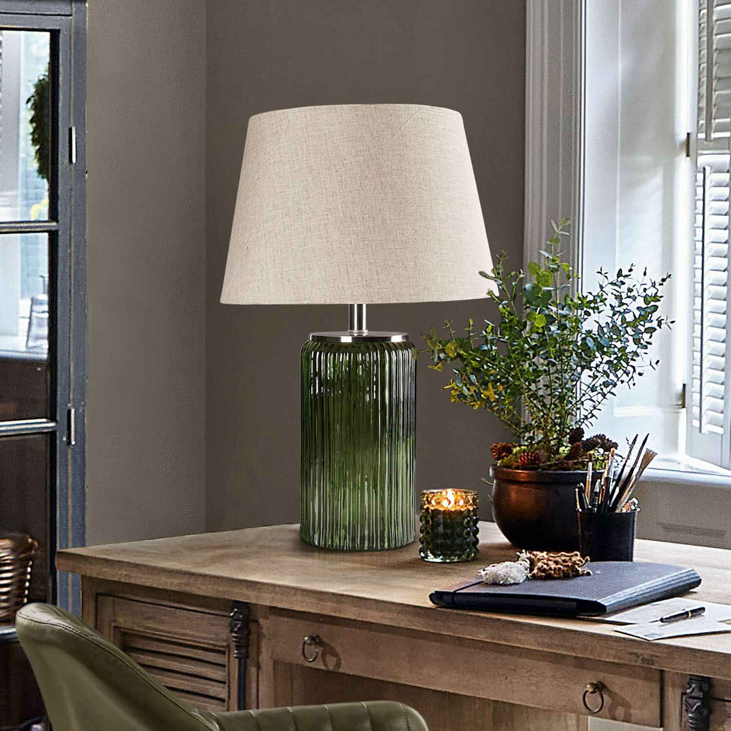 Stolní lampa Thalindor Stolní lampa ze zeleného skla s béžovým stínidlem na dřevěném vintage stole
