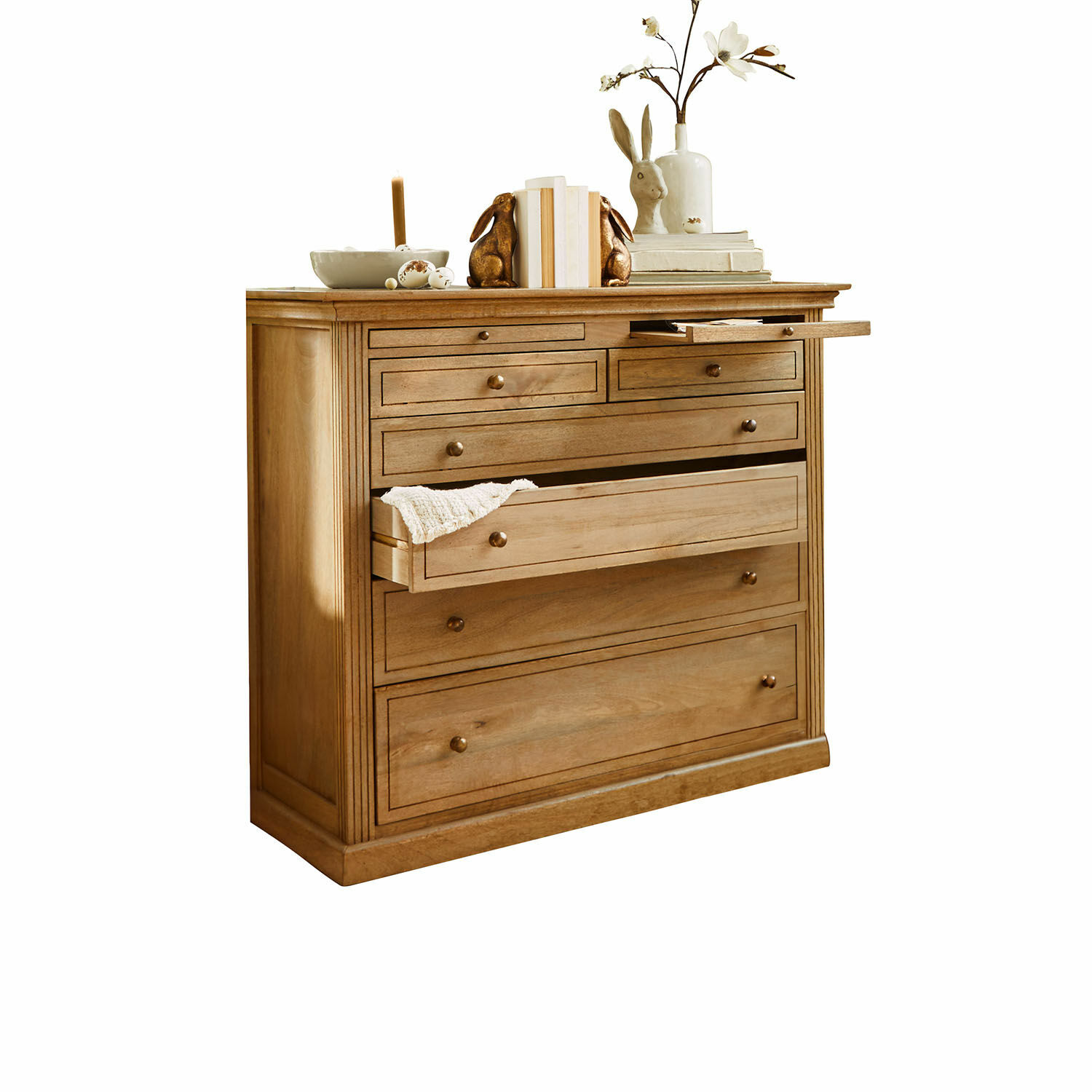 Dřevěná komoda s několika zásuvkami a dekoracemi na vrchu, přírodní barva dřeva