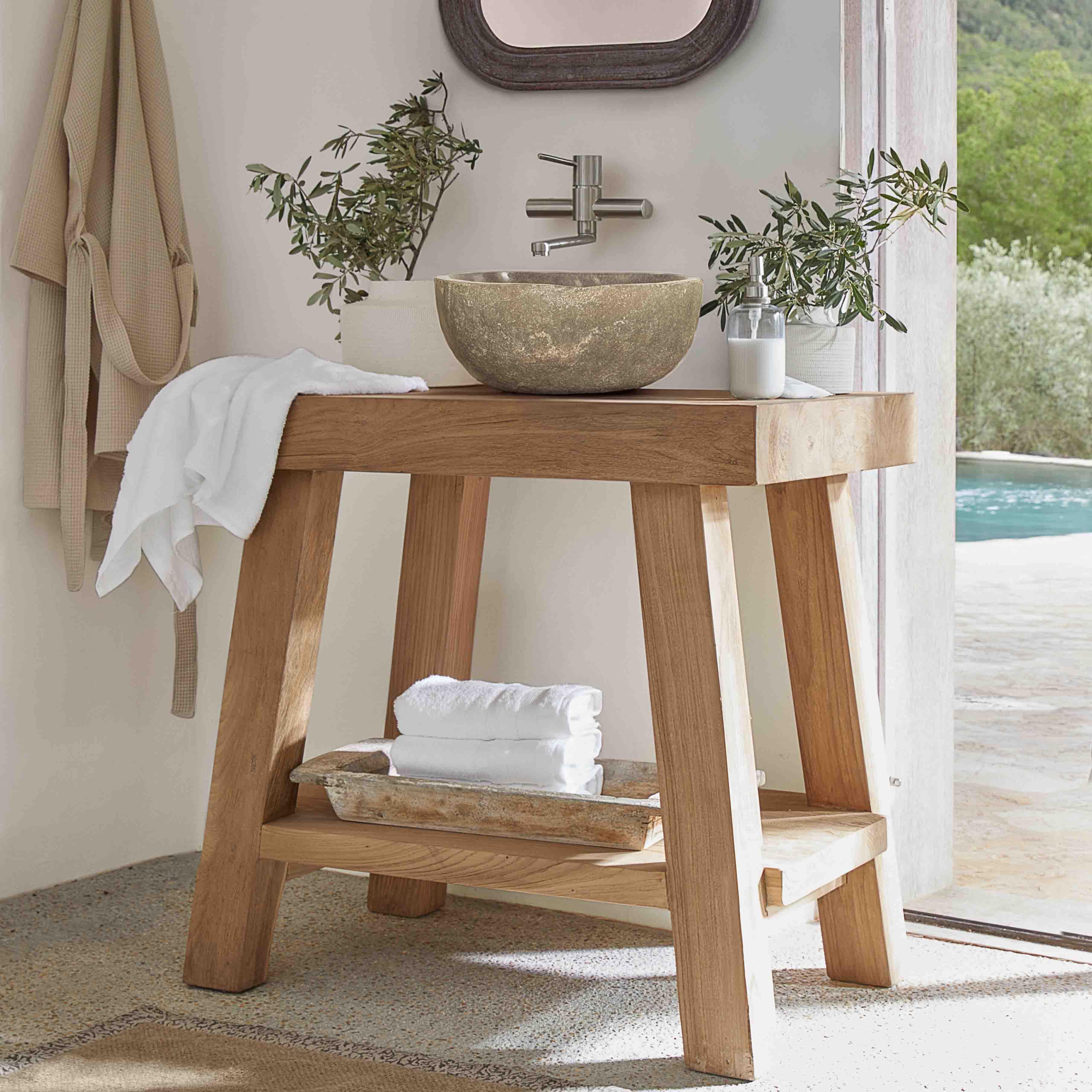 Dřevěná koupelnová konzole s kamenným umyvadlem a bílými ručníky v světlém interiéru