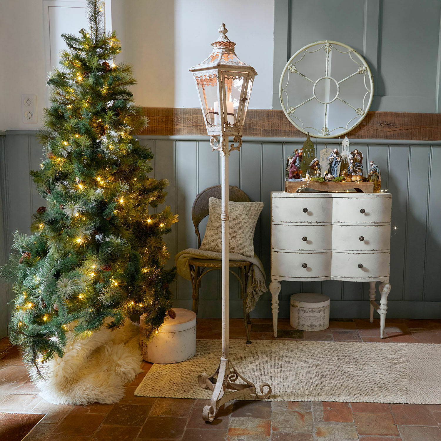Lucerna Lumière Élysée Bílá kovová stojací lucerna s ozdobným vzorem v rustikálním interiéru s vánočním stromkem a komodou