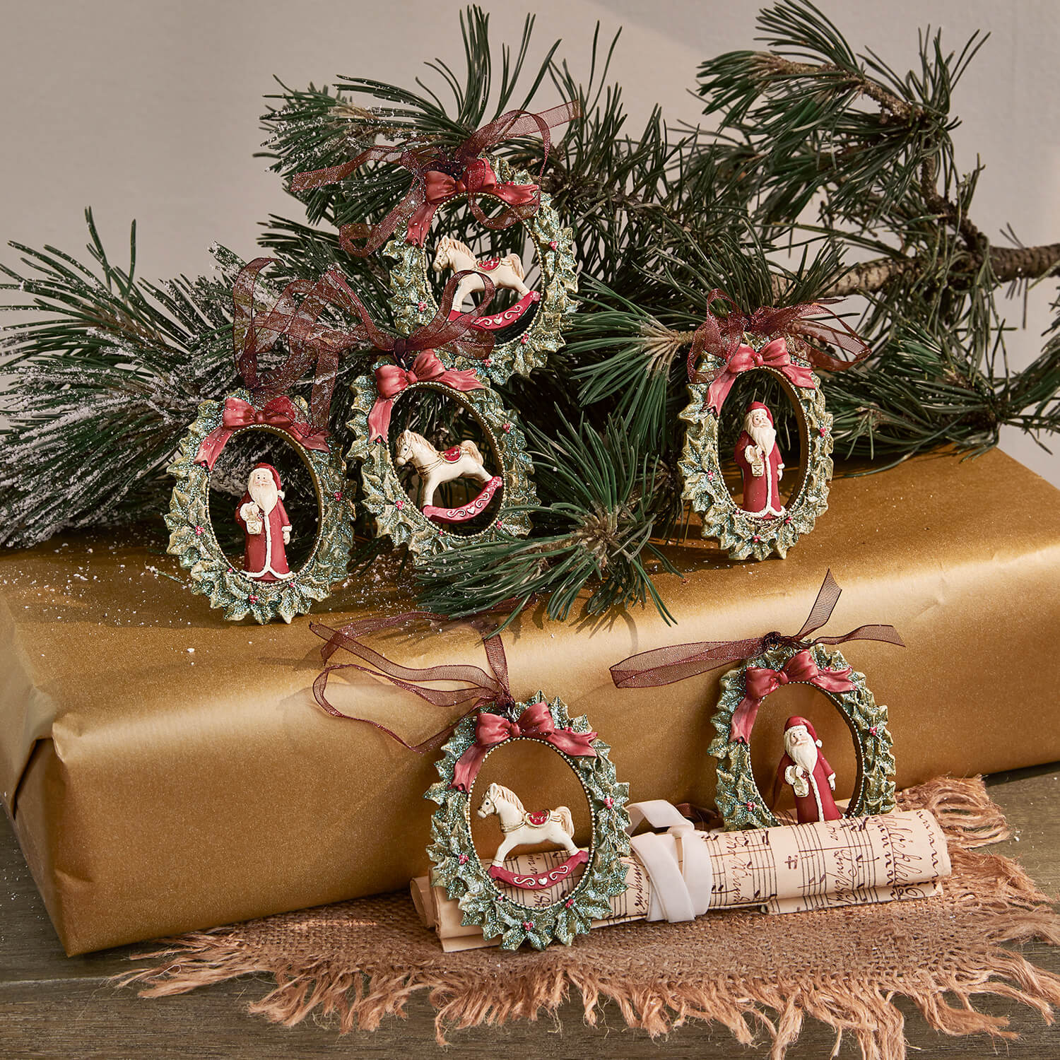 Sada vánočních ozdob se zelenými věnci, červenými mašlemi a figurkami Santa Clause a houpacího koně