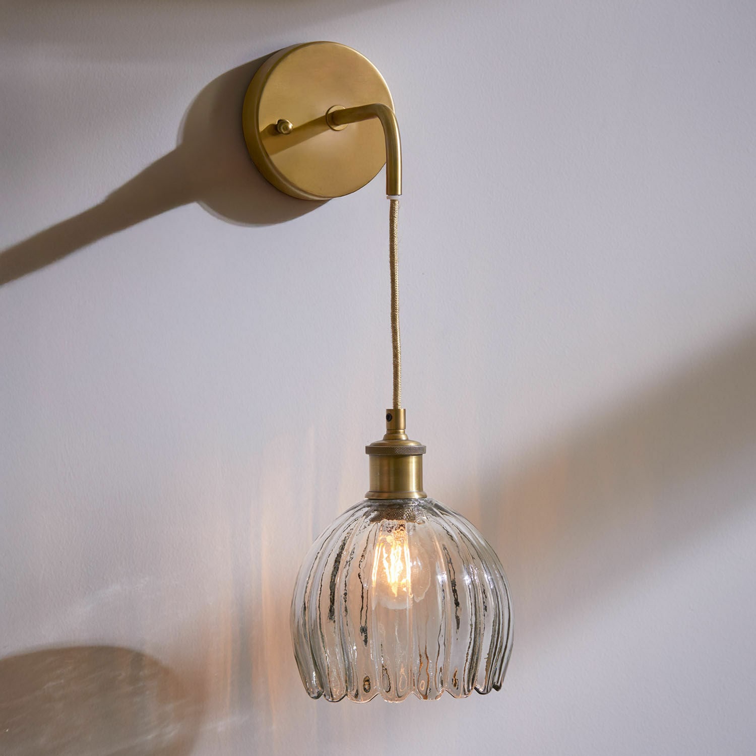 Nástěnné svítidlo Druaila Nástěnné svítidlo z vintage skla a mosazi s průhledným stínidlem a teplým světlem