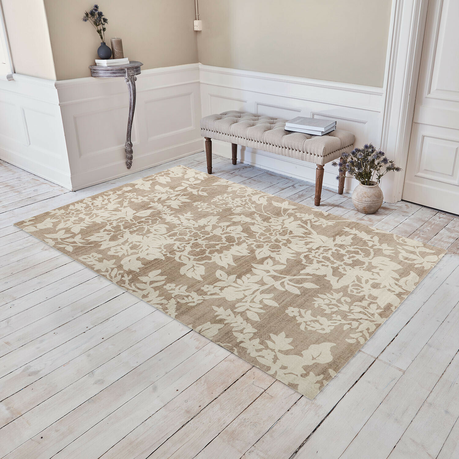 Koberec Casamira Béžový koberec s květinovým vzorem na světlé dřevěné podlaze v elegantním interiéru s čalouněnou lavicí