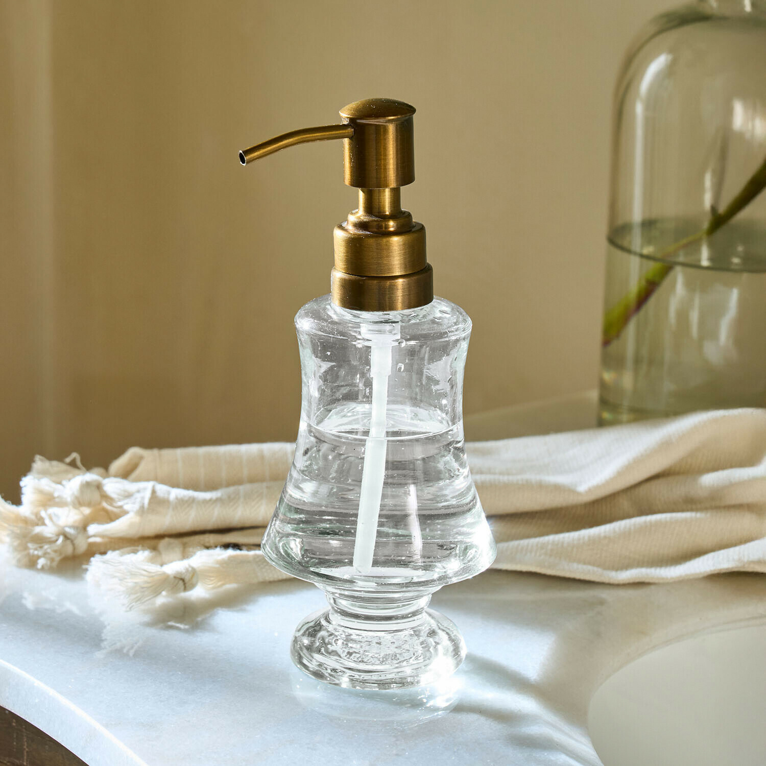 Průhledný skleněný dávkovač mýdla s mosazným pumpičkou na koupelnovou desku
