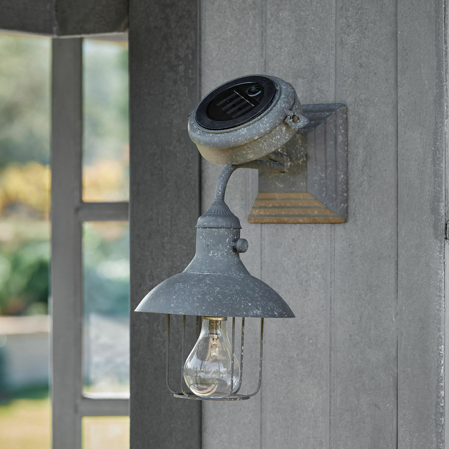 Nástěnná solární lampa Anniviers Šedé kovové nástěnné svítidlo s kloboukem a žárovkou v rustikálním stylu pro venkovní osvětlení