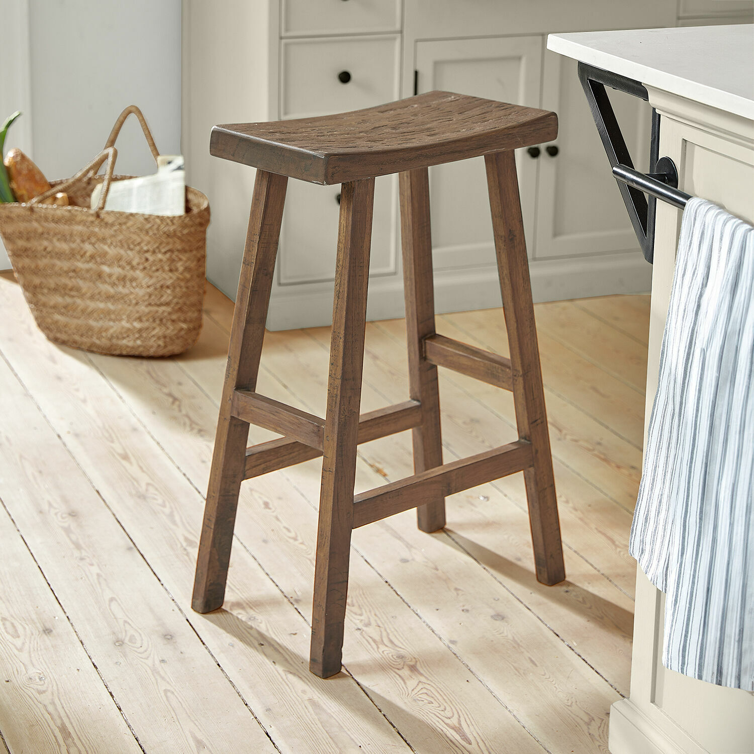 Stolička Nael Hnědá dřevěná barová stolička na světlé podlaze v kuchyni