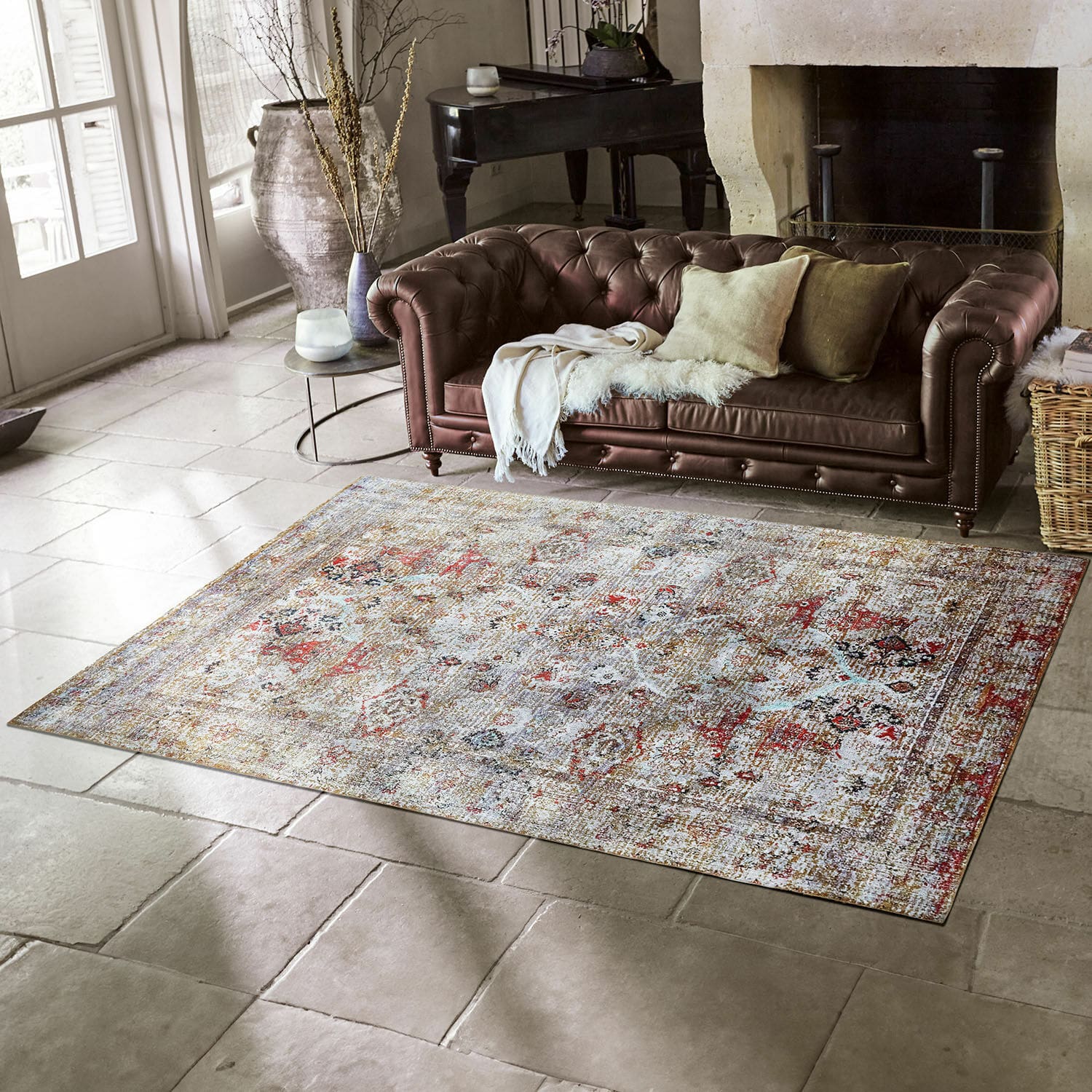 Dekorativní vintage koberec v teplých barvách na kamenné podlaze v obývacím pokoji