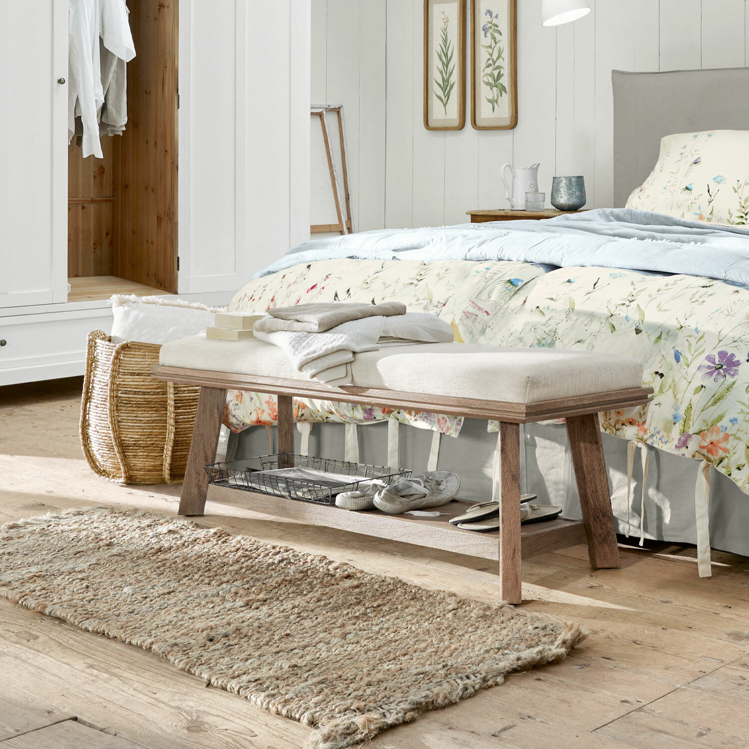 Lavice Abington Dřevěná lavice s světlým polstrovaným sedákem v ložnici, přírodní koberec a květinová výzdoba