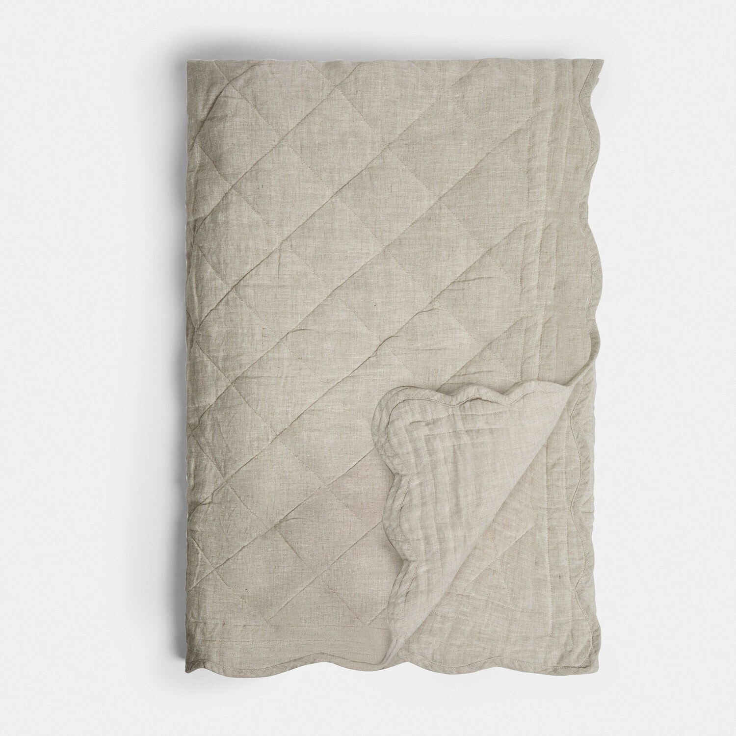 Béžová prošívaná lněná přikrývka s ozdobným vlnitým okrajem, měkká přírodní látka do ložnice