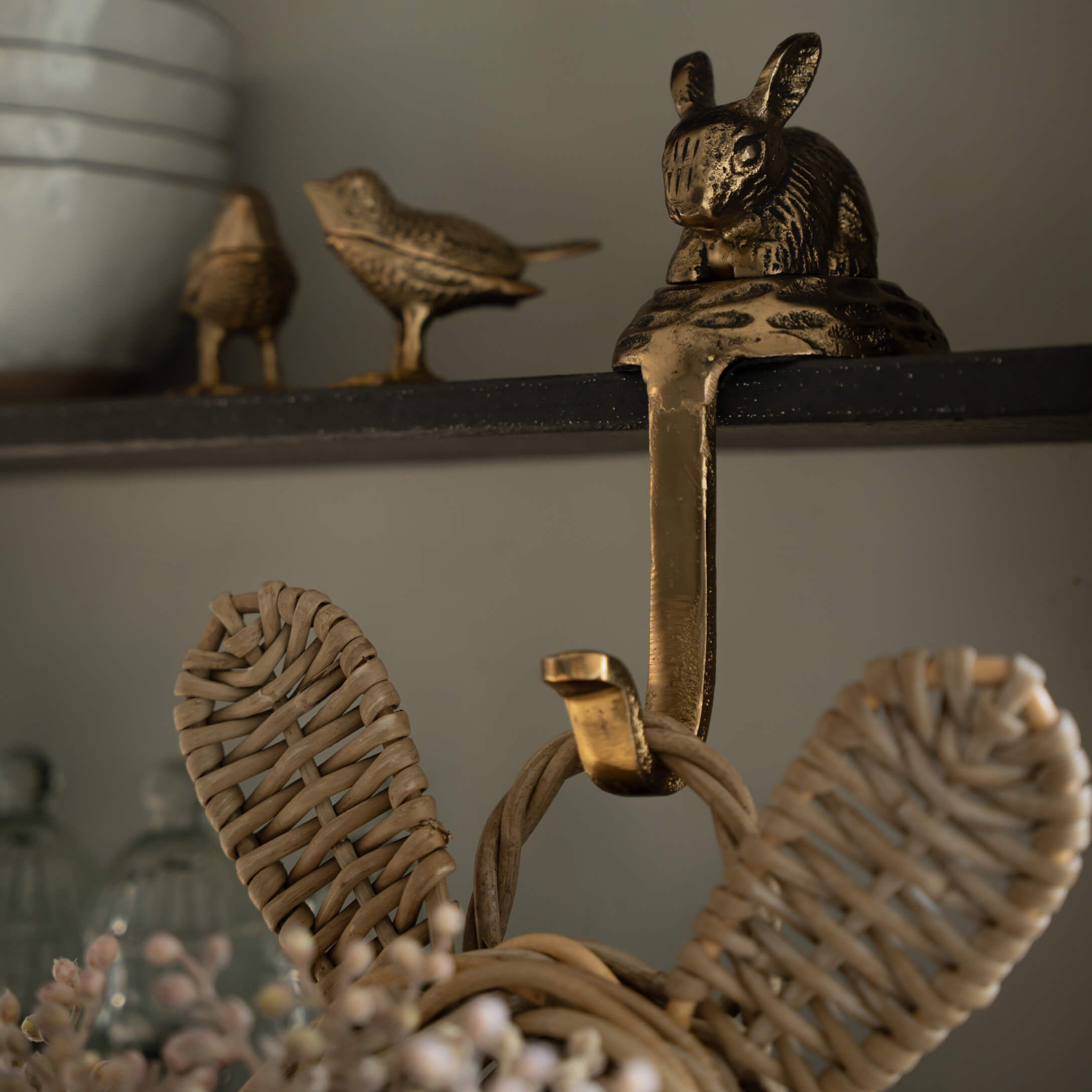 Zlatý mosazný věšák s motivem králíka a ptáků na černé polici pro domácí dekoraci