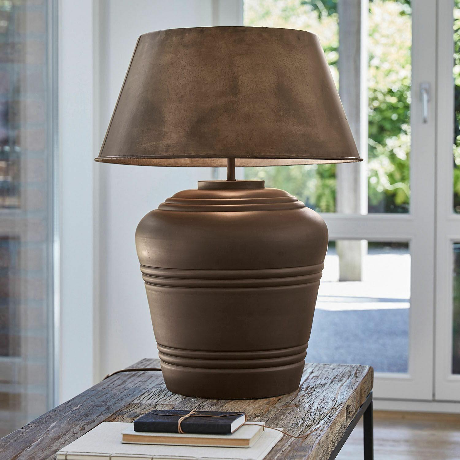 Stolní lampa Morice Hnědá keramická stolní lampa s odstínem na dřevěném stole v světlé místnosti