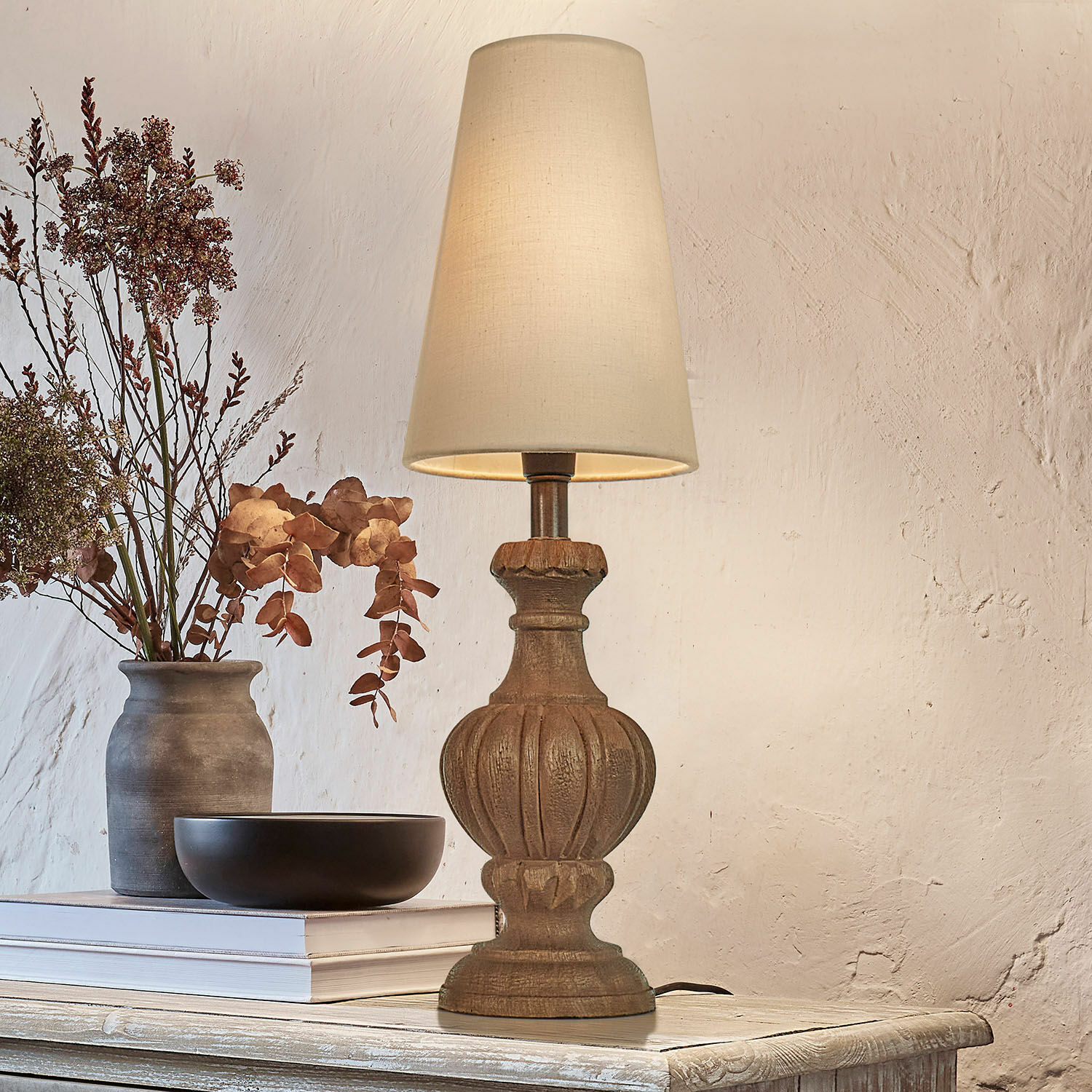 Stolní lampa Airoux Stolní lampa s dřevěným podstavcem a krémovým stínidlem na rustikálním stole s dekorací