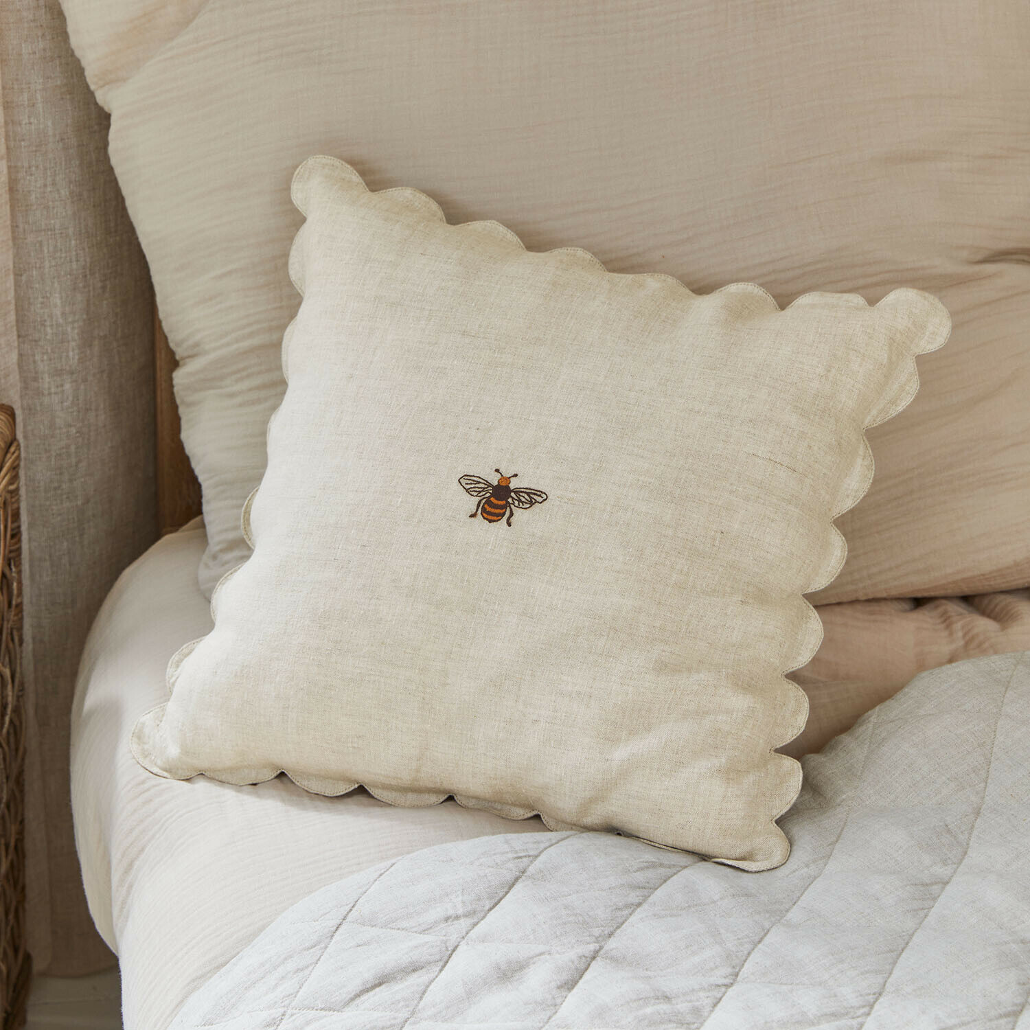 Béžový lněný polštář s vlnitým okrajem a vyšívanou včelou, dekorace ložnice