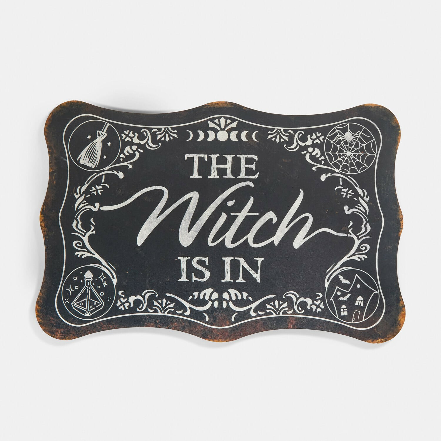 Dekorativní tabulka Talmora Černá kovová dekorativní cedule s nápisem The Witch Is In a halloweenovými motivy