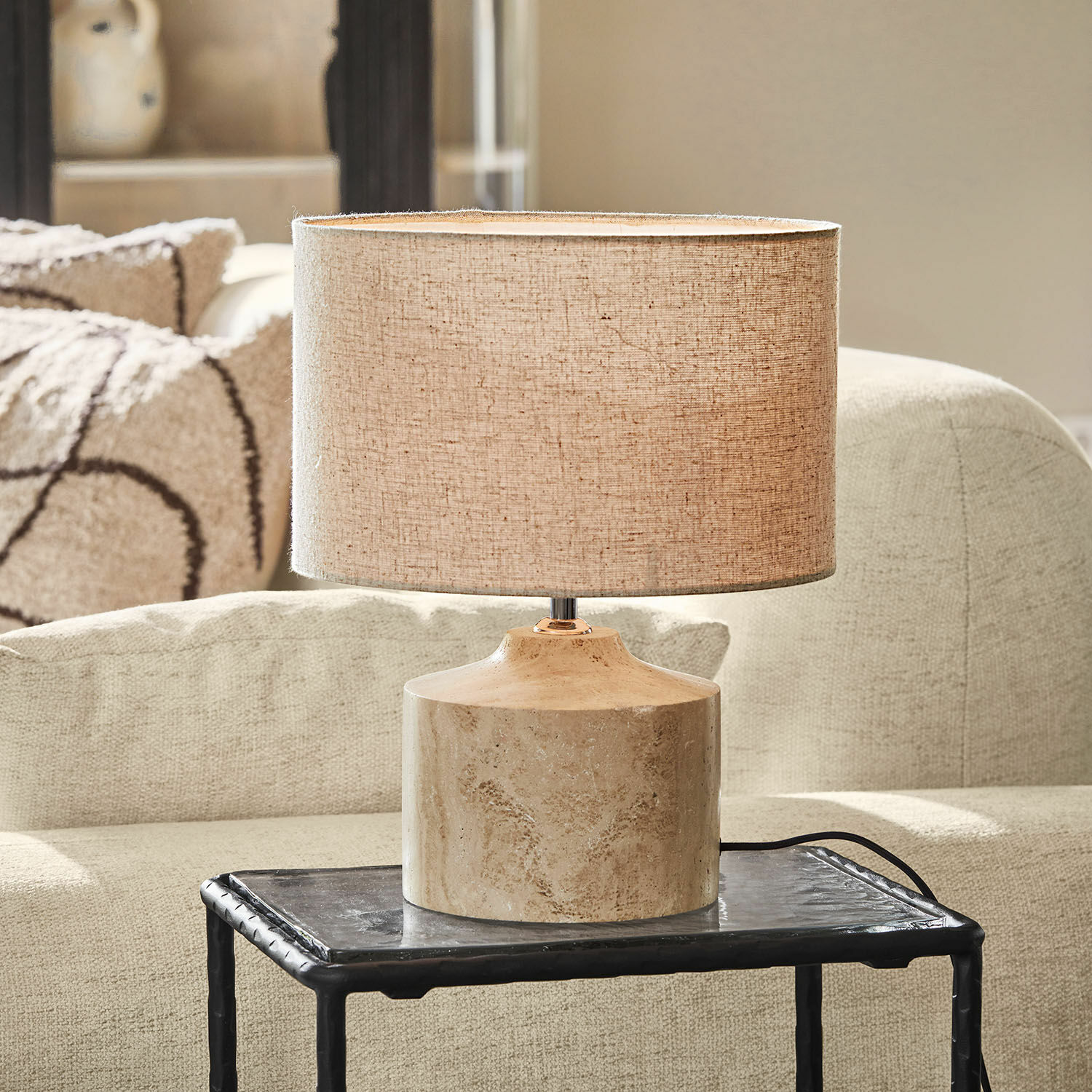 Stolní lampa Caleneuve Stolní lampa s béžovým stínidlem a mramorovým podstavcem na černém stolku v obývacím pokoji