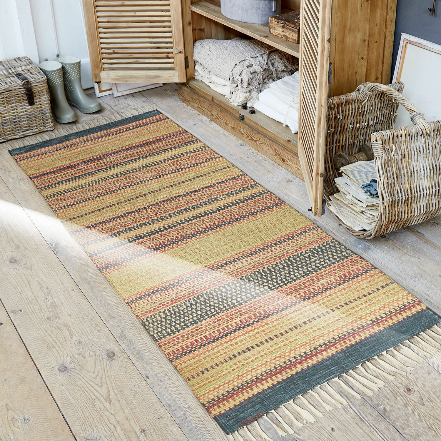 Běhoun do interiéru i exteriéru Atlanta Pruhovaný koberec v teplých barvách s třásněmi na dřevěné podlaze v rustikálním stylu