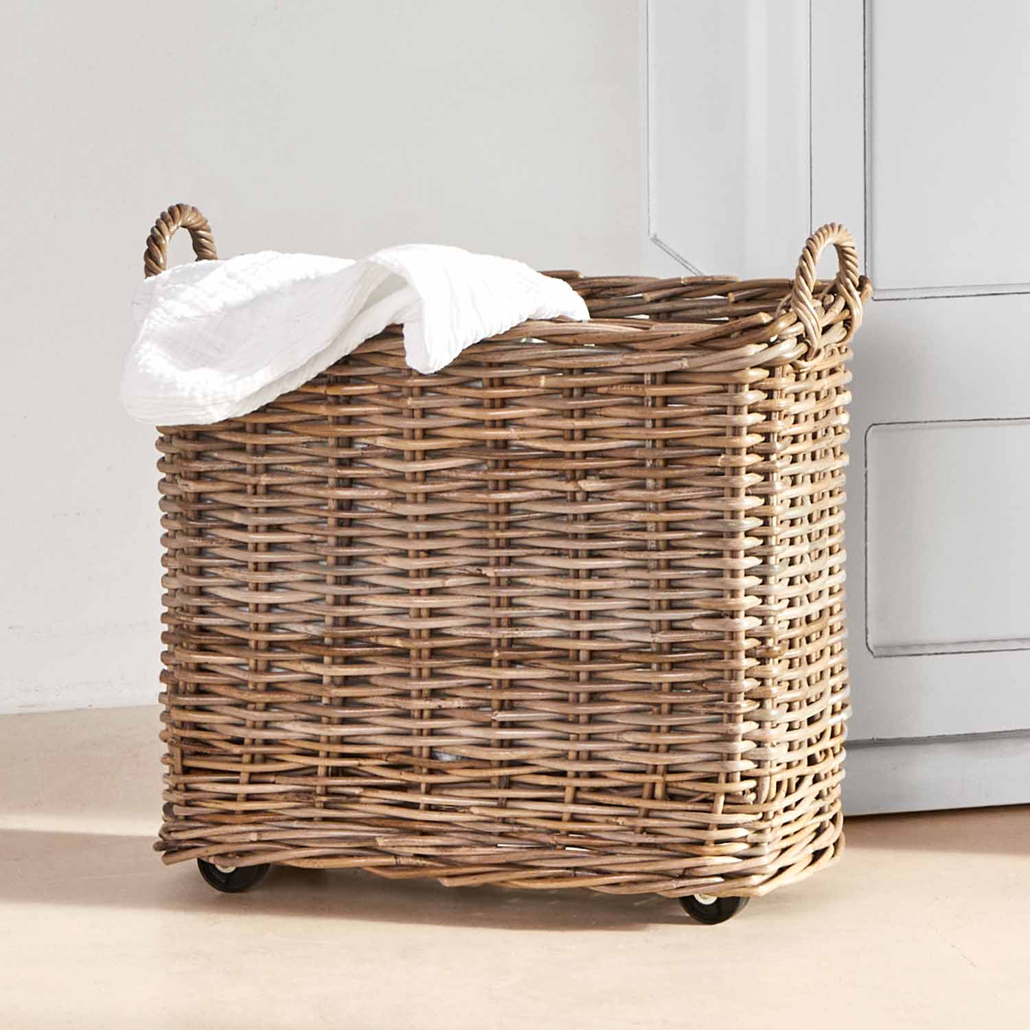 Velký proutěný koš na kolečkách v přírodní barvě s bílou látkou na skladování