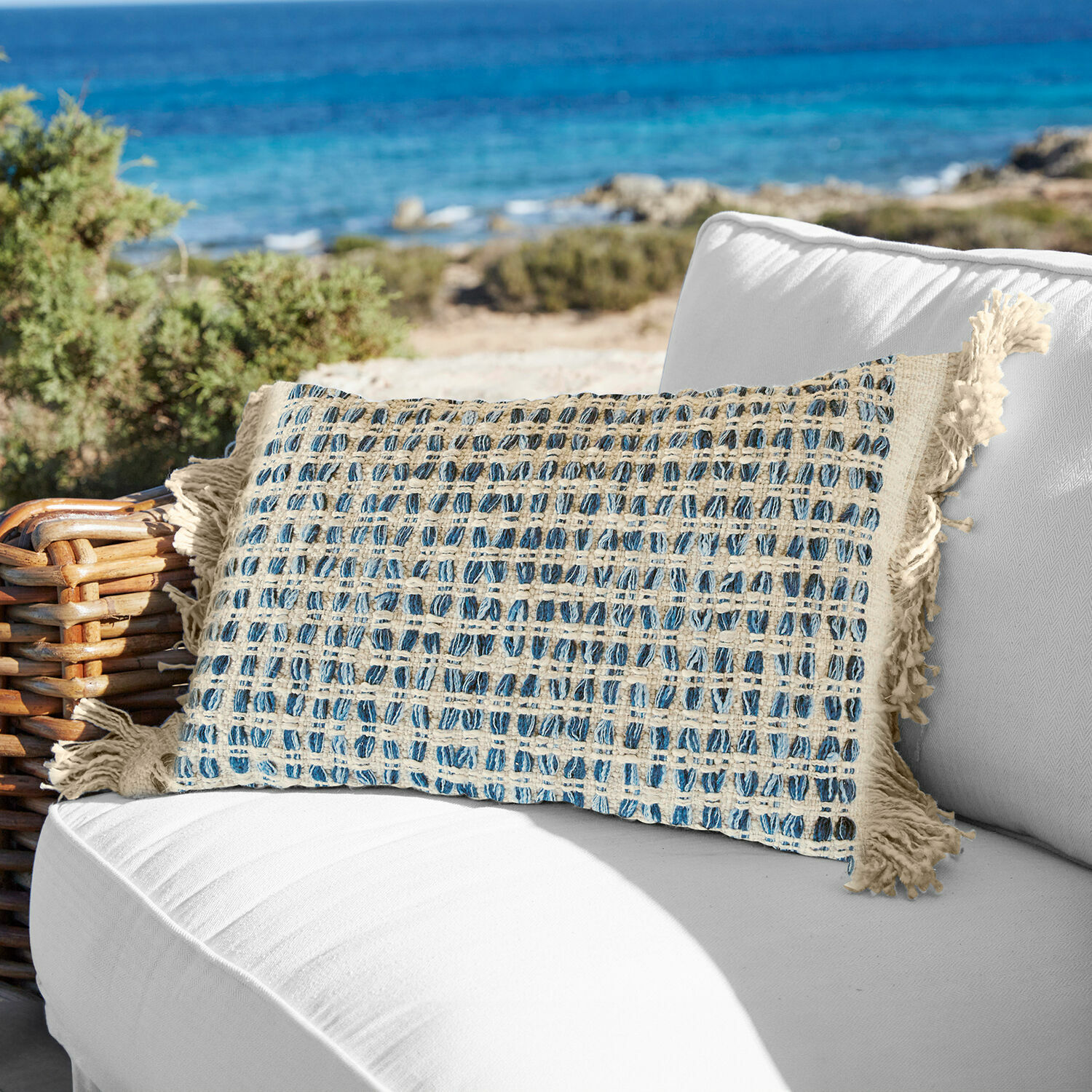 Povlak na polštářek Monrovie Dekorační bavlněný polštář v krémovo-modré kostce s třásněmi na bílém venkovním gauči