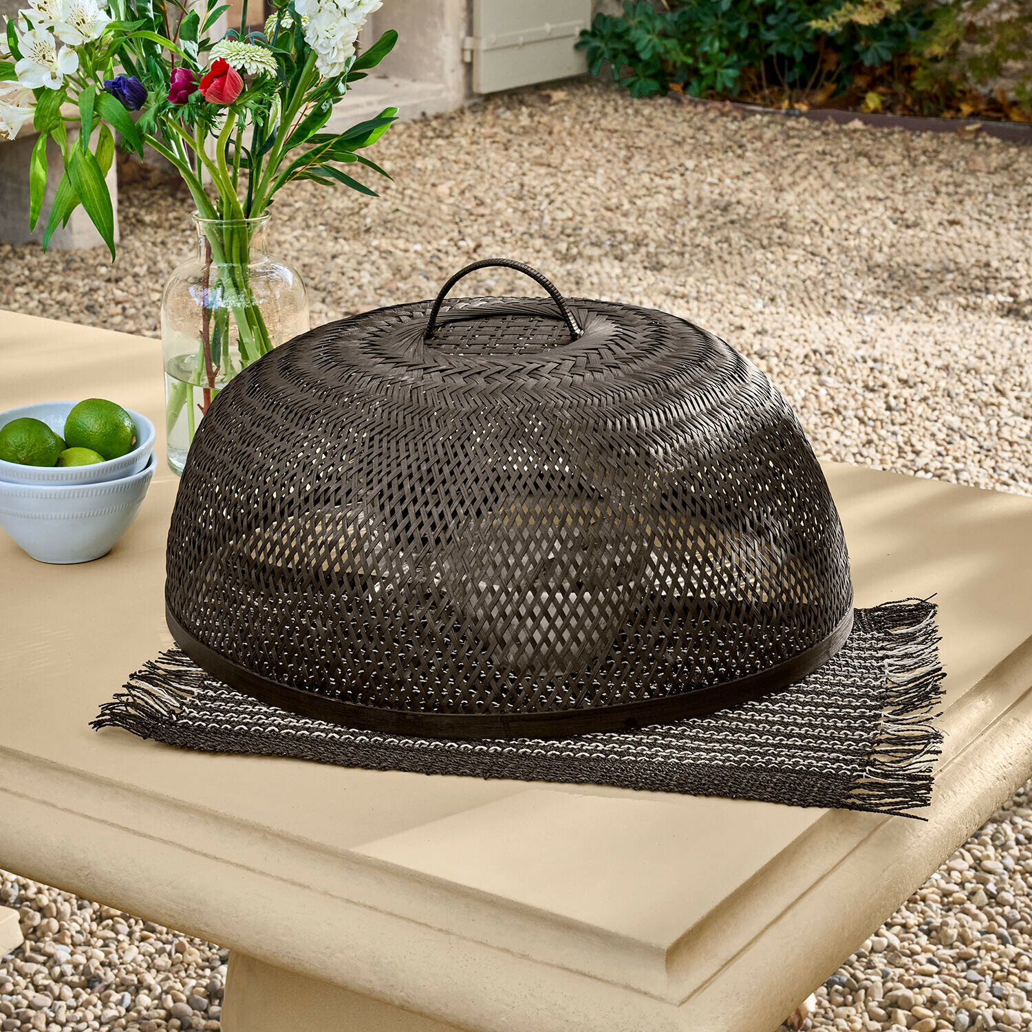 Černý pletený poklop z ratanu na zahradním stole, ochrana jídla před hmyzem