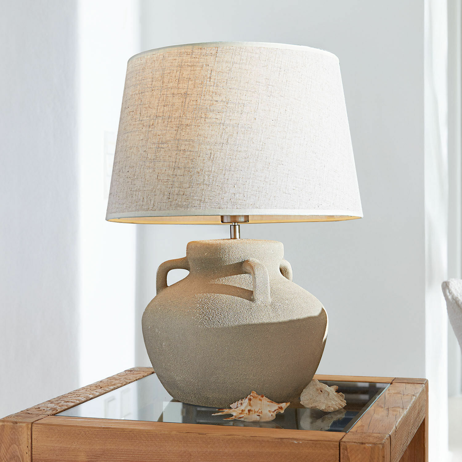 Stolní lampa Parya Stolní lampa s béžovou keramickou základnou a světlým stínidlem na dřevěném stolku