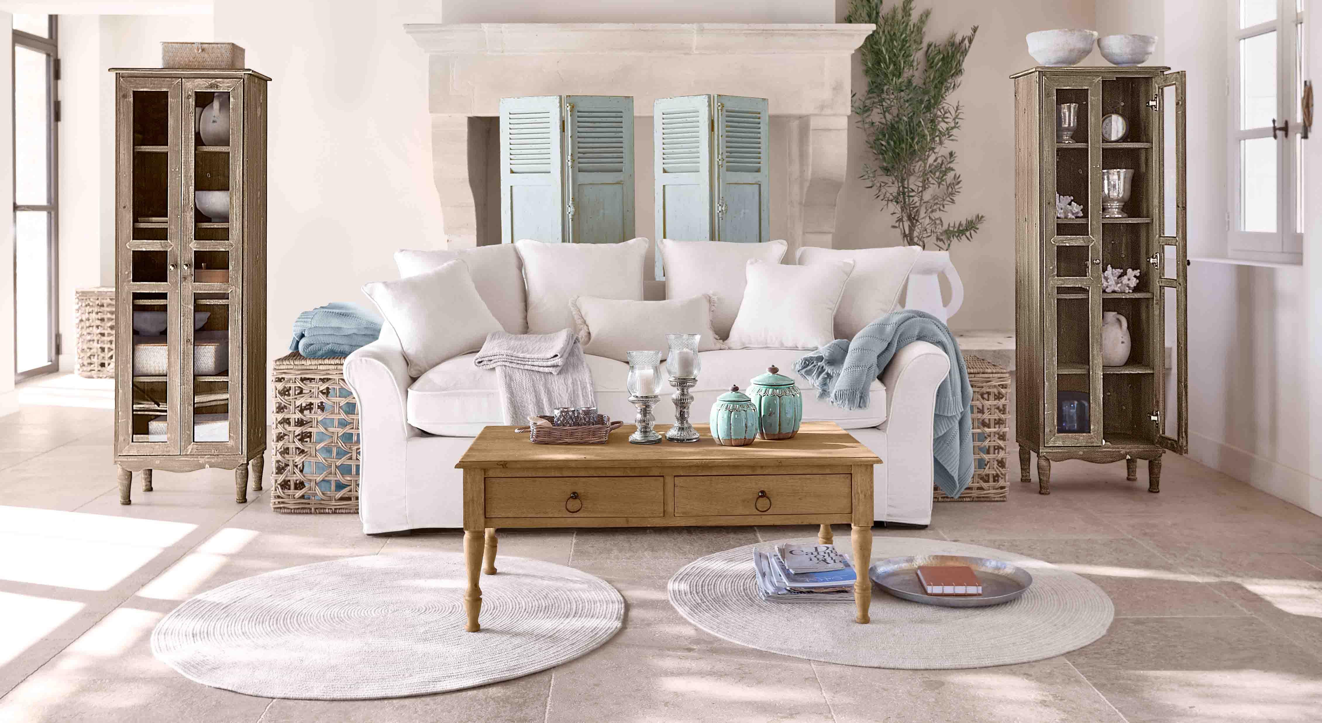 Pohodlný obývací pokoj s bílou pohovkou, dřevěným konferenčním stolkem a dvěma vintage skříňkami