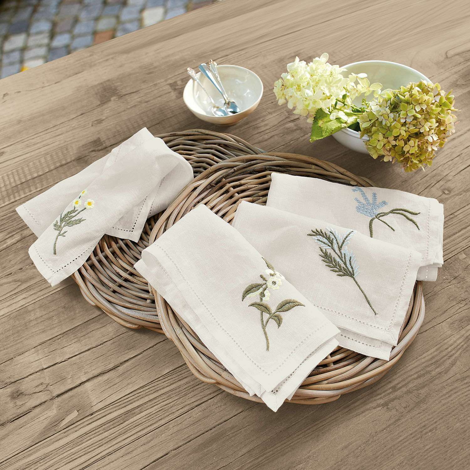 Ubrousky, 4dílná sada Lentilly Lněné ubrousky s květinovou výšivkou v přírodní barvě na proutěném koši na dřevěném stole