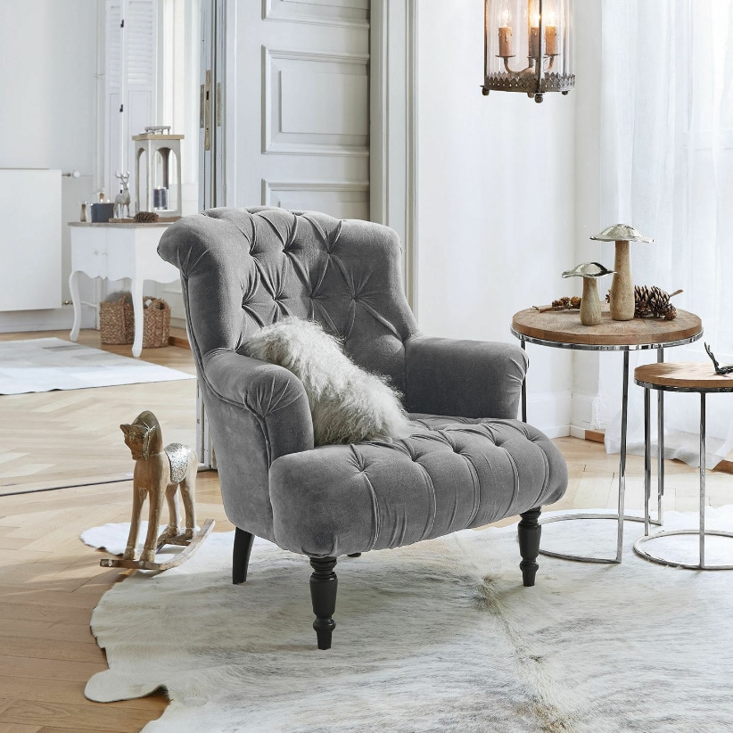 Šedé křeslo Parranquet z měkkého materiálu v elegantním obývacím pokoji s dřevěnou podlahou a dekoracemi