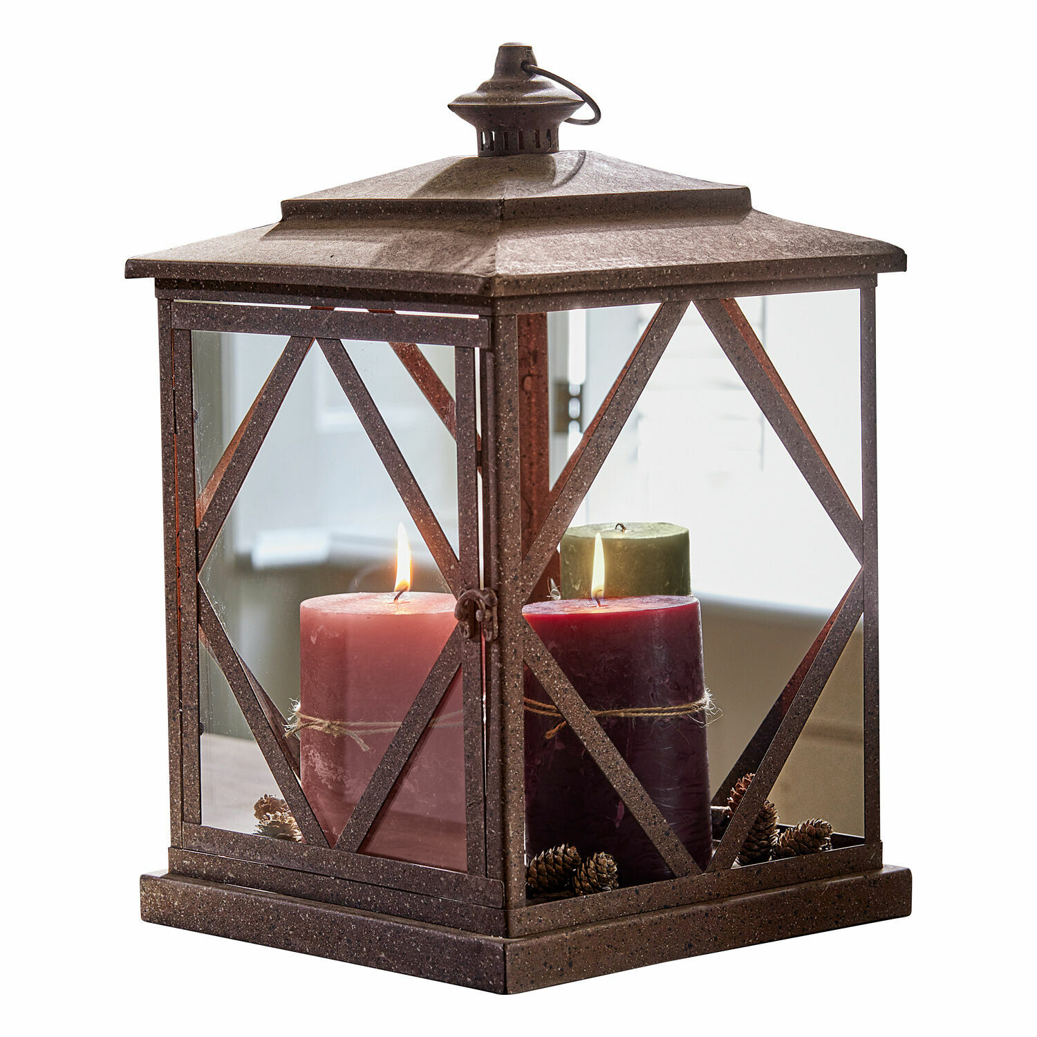 Hnědá kovová lucerna se třemi hořícími svíčkami a šiškami uvnitř