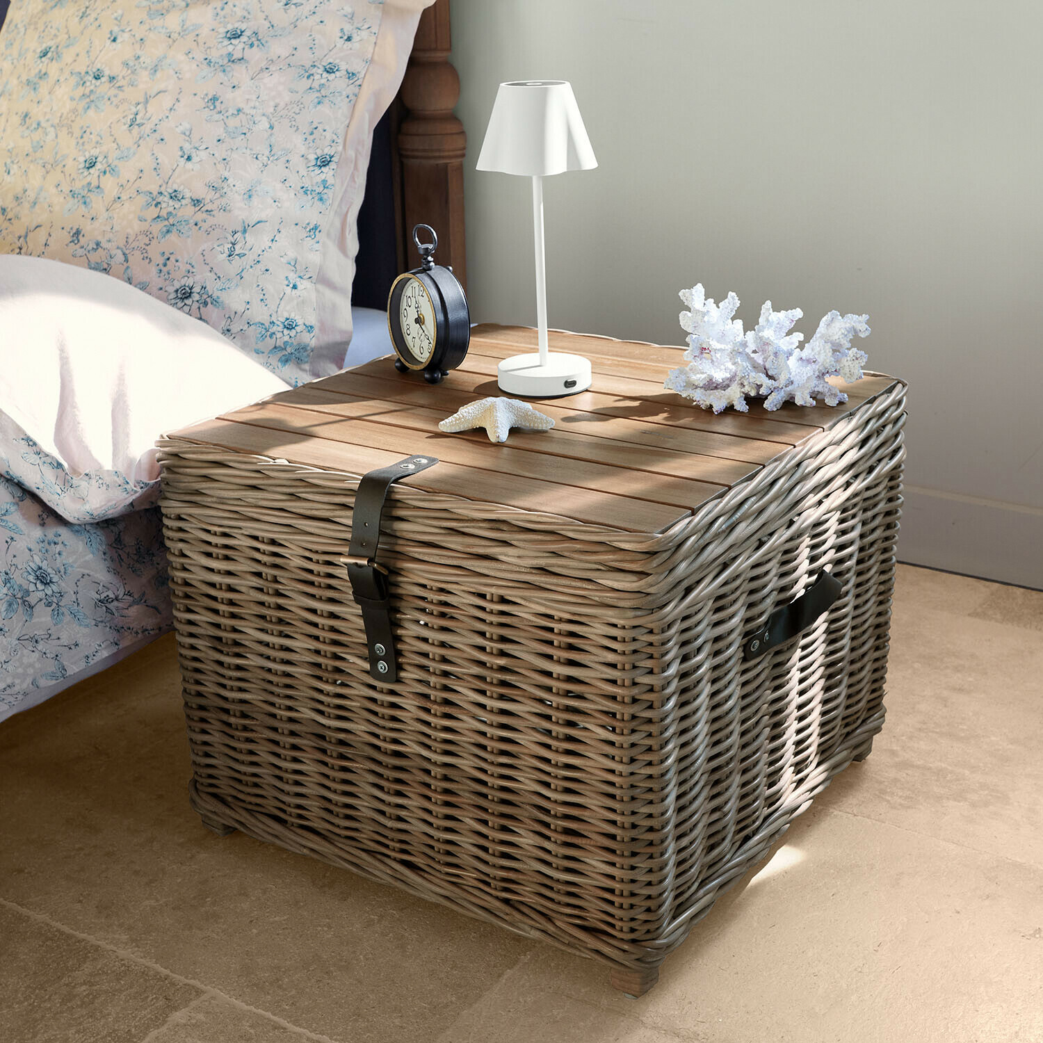 Čtvercový noční stolek z šedého proutí a dřeva s lampou a mořskými dekoracemi na desce