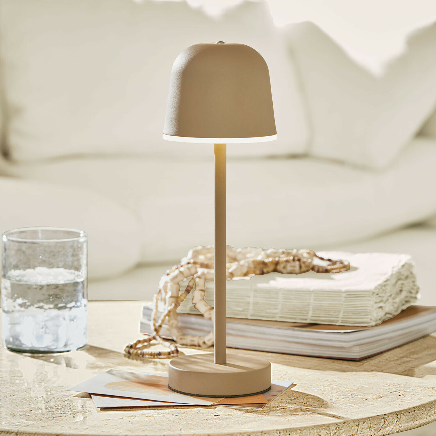 Moderní růžová stolní lampa z kovu na mramorovém stole v světlém obývacím pokoji