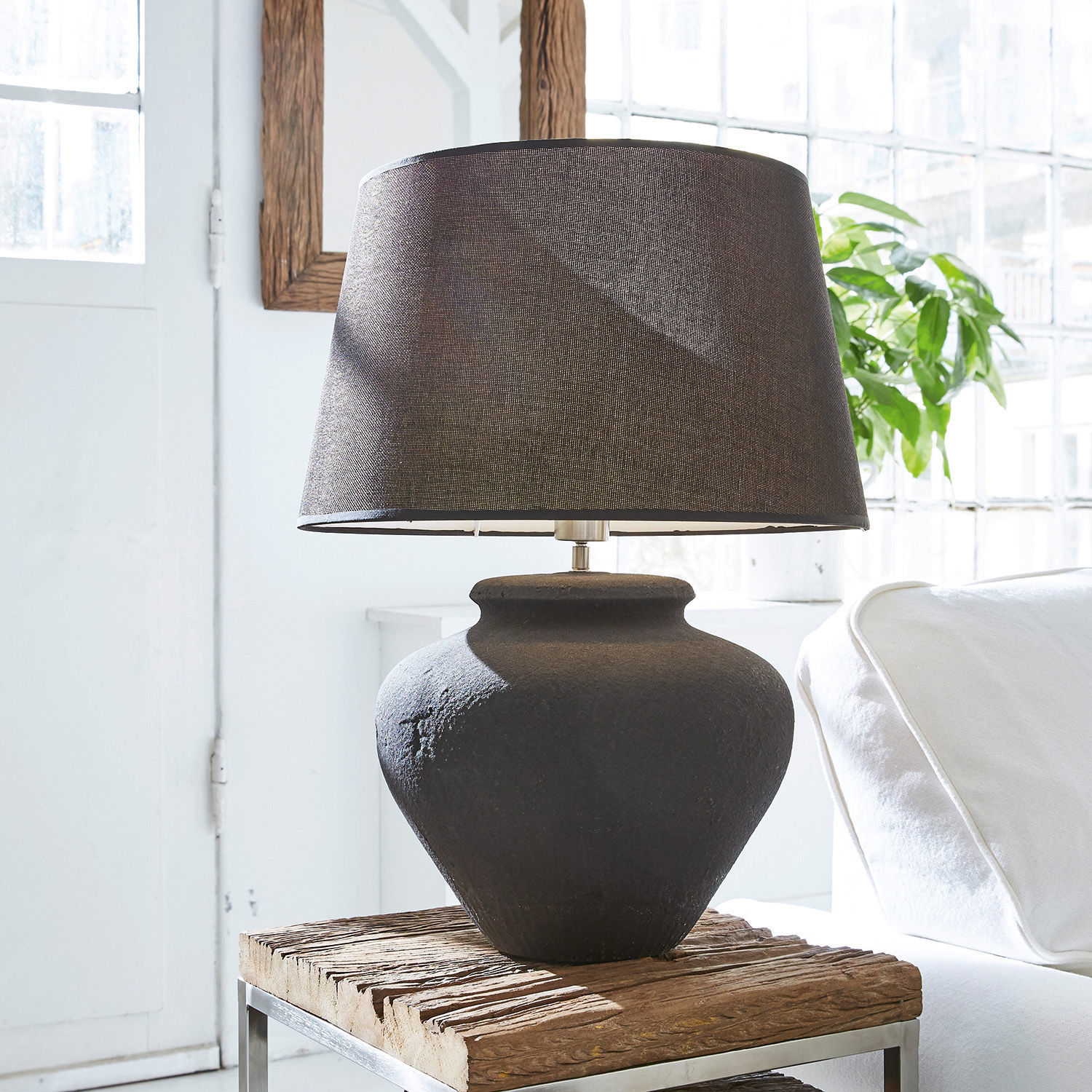 Stolní lampa Bandol Černá keramická stolní lampa s textilním stínidlem na dřevěném stolku v světlém interiéru