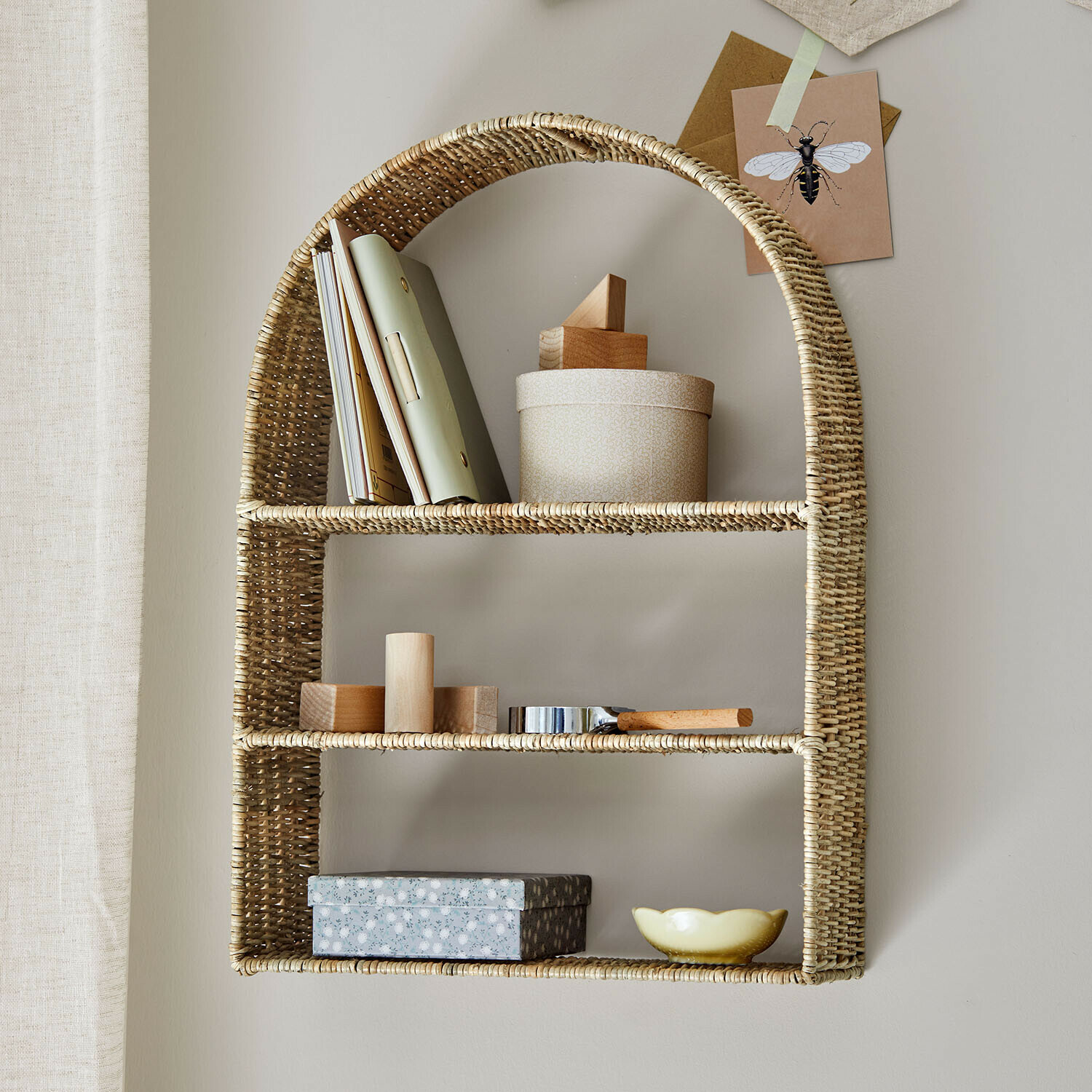 Nástěnná police Mavellan Nástěnná polička z přírodního ratanu s dekoracemi a knihami pro úložný prostor