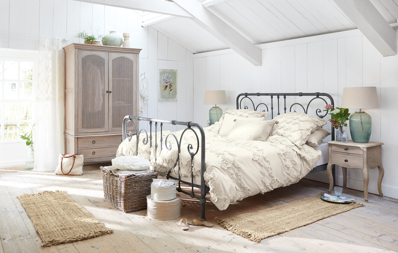 Ložnice ve stylu shabby chic s kovovou postelí a krémovým bavlněným povlečením, přírodní doplňky