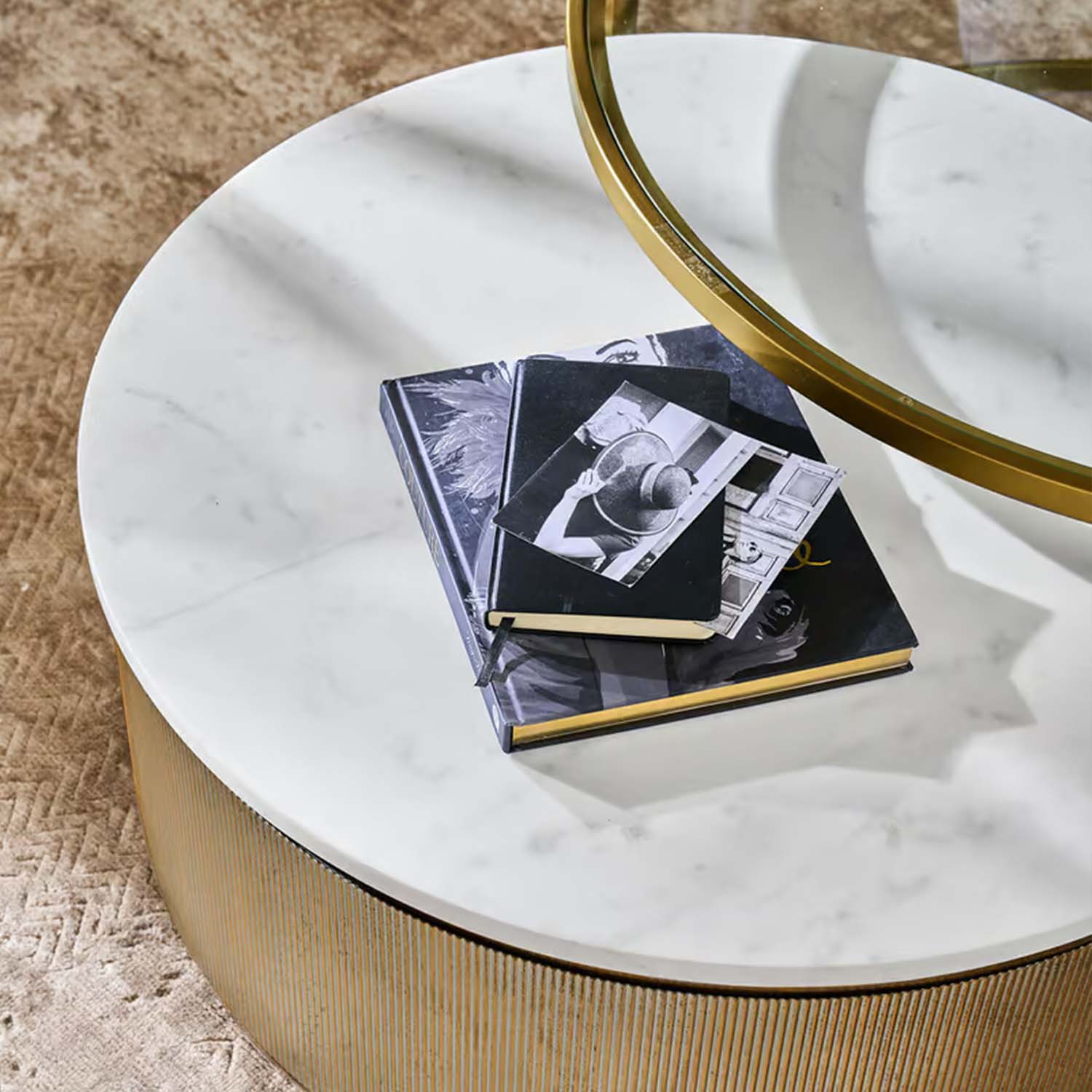 Kulatý konferenční stolek s bílou mramorovou deskou a zlatou základnou na béžovém koberci