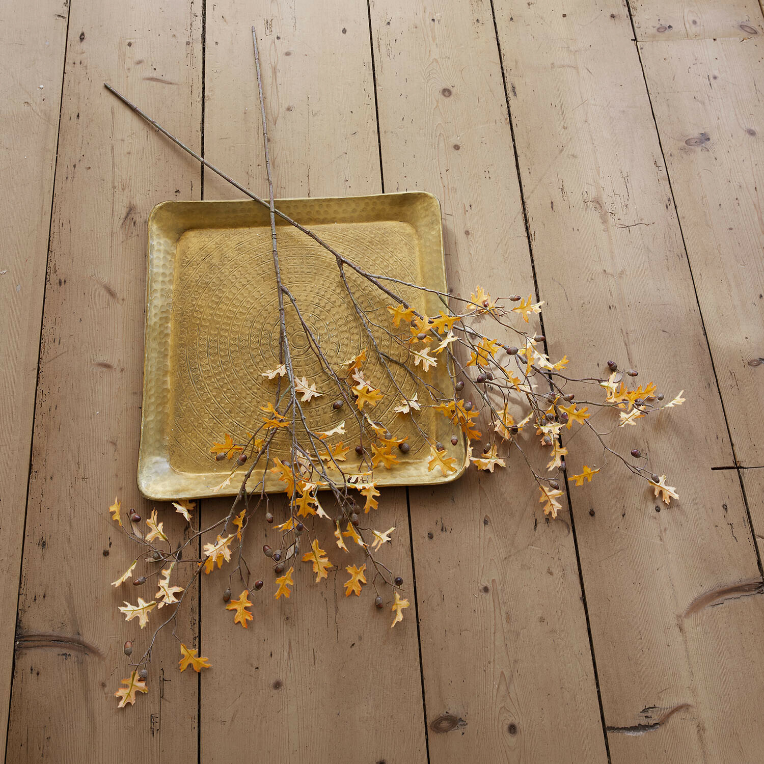 Dekorativní větvičky, 2dílná sada Sagges Čtvercový mosazný tác s raženým vzorem a větvičkami se žlutými listy na dřevěné podlaze