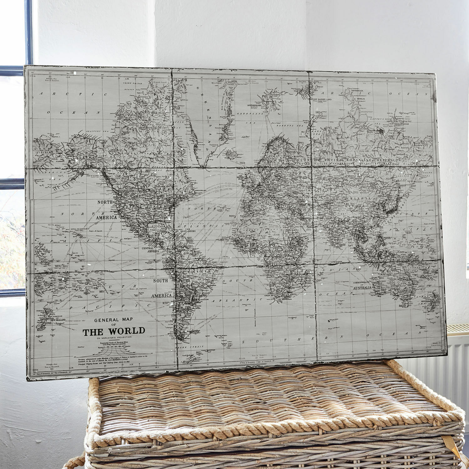 Obraz Macolin Vintage mapa světa v šedých odstínech na proutěném koši jako interiérová dekorace