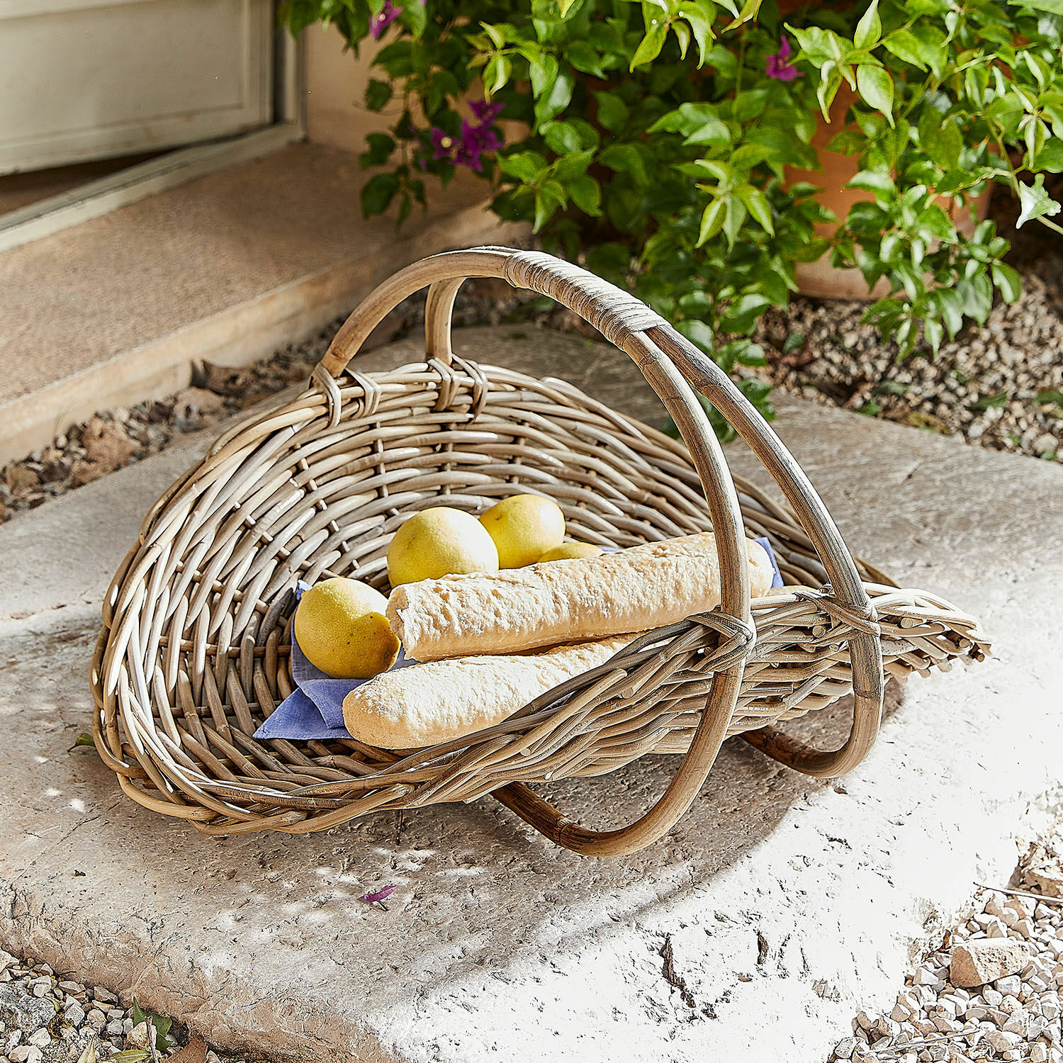 Proutěný košík Drillaux Přírodní proutěný koš s rukojetí, obsahující bagety a citrony, vhodný pro skladování