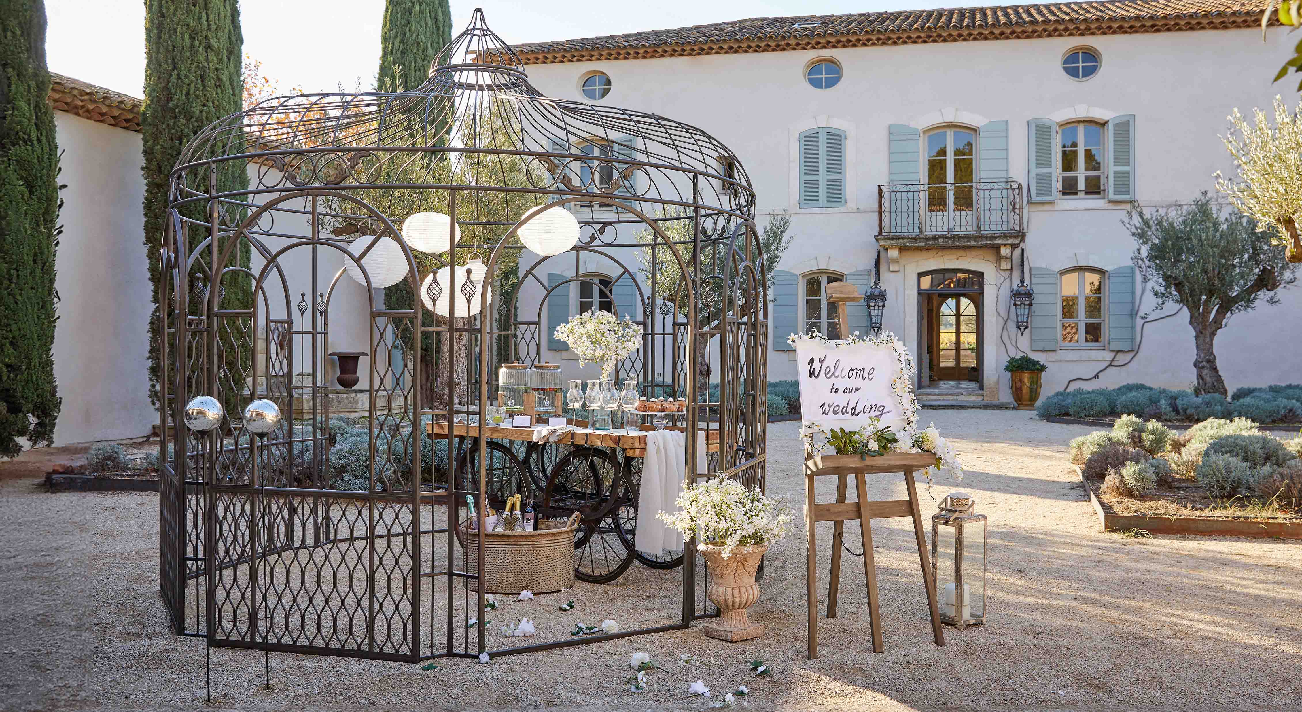 Kovová altán s dekorativním vzorem na zahradě s stolem a květinami pro svatební oslavu