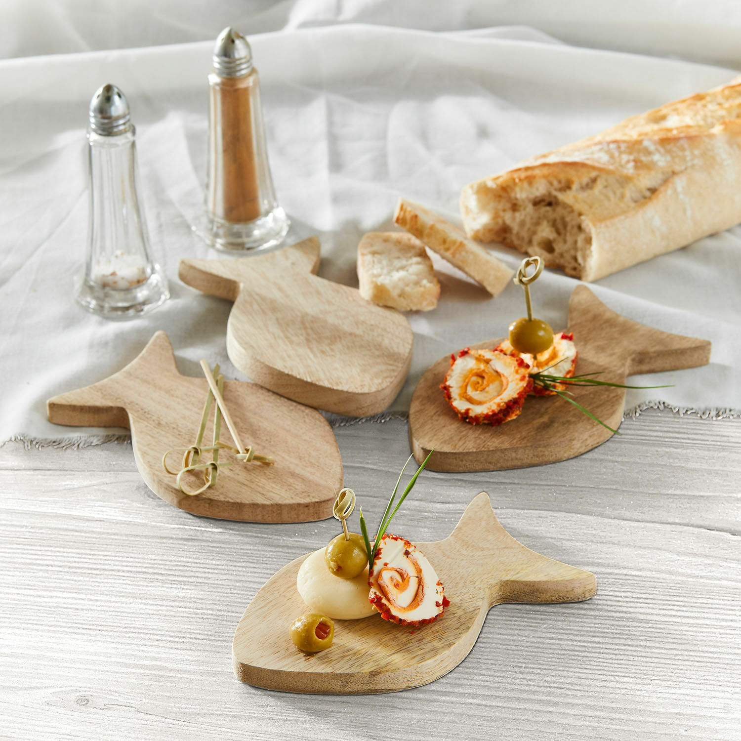 Podložka, 4dílná sada Magnan Dřevěné prkénka ve tvaru ryby s olivami a sýrovými jednohubkami na stole