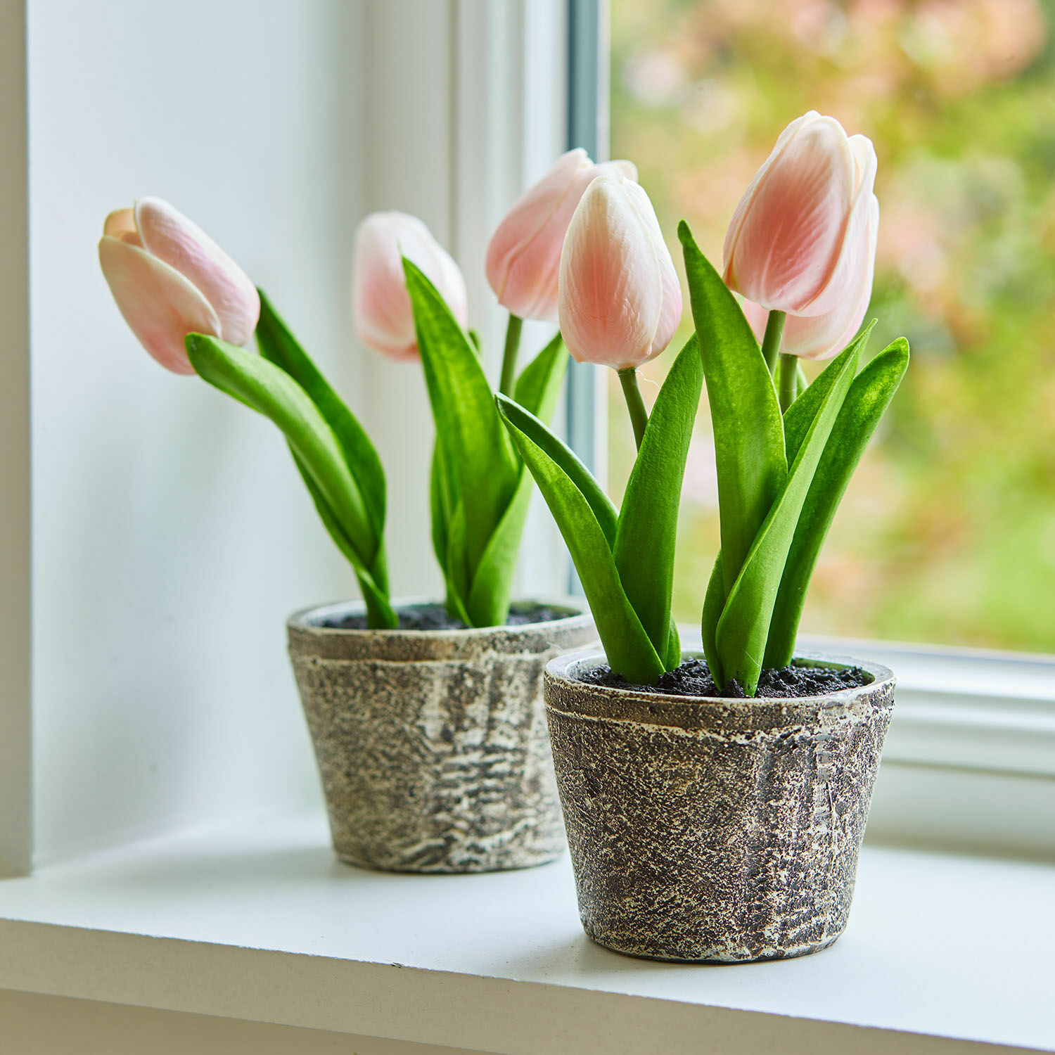 Dekorační tulipány, 2dílná sada Zéphine Jemné růžové tulipány v šedých kamenných květináčích na okenním parapetu, jarní dekorace